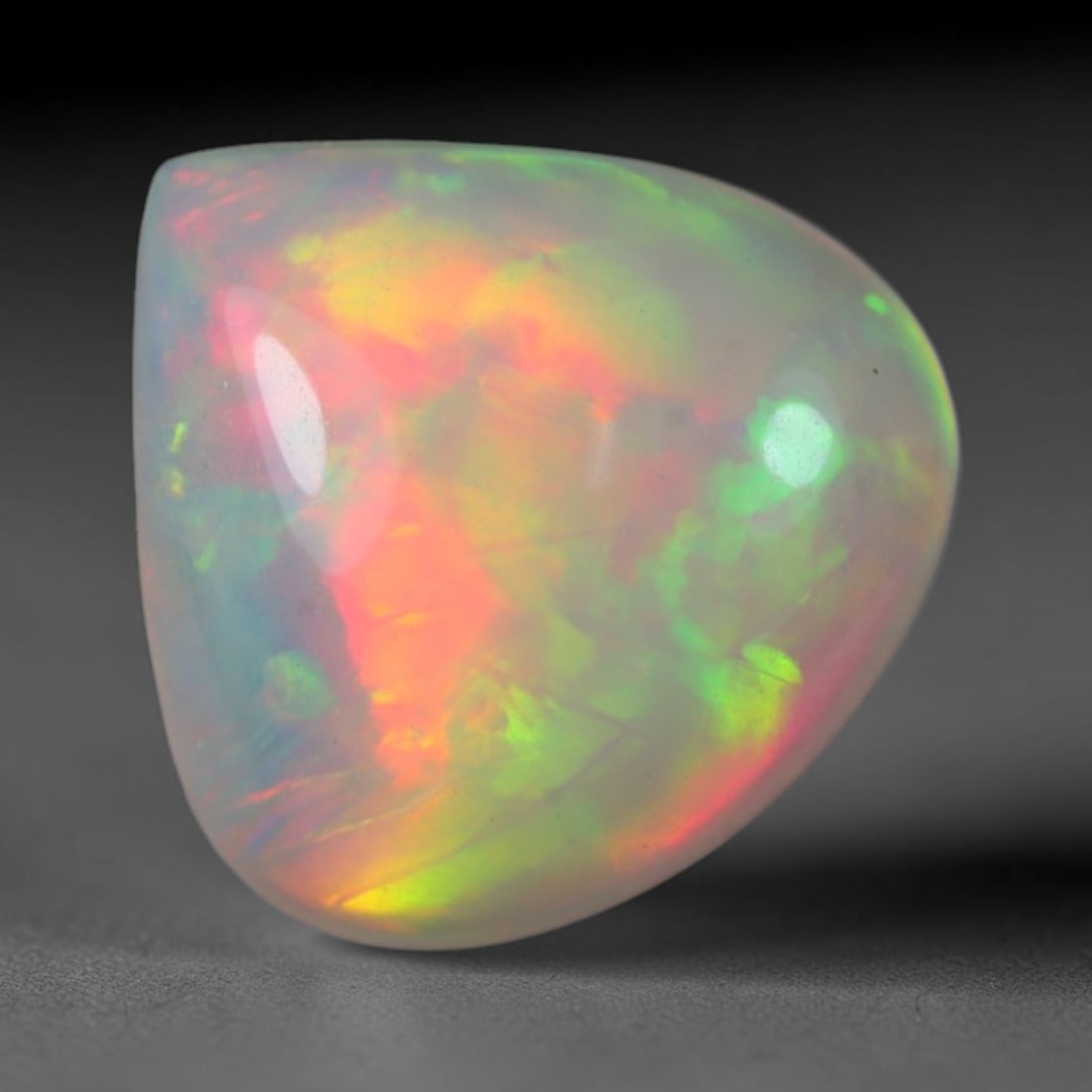 2.00 Carats Natural Ethiopian Welo Opal Oval Cabochon Loose Gemstone, 42XV: Natural Ethiopian Welo opal polished oval cabochon loose gemstone, luminous translucent milky white base stone with vivid multi-hued play-of-color featuring bright emerald green, lime yellow, soft blu