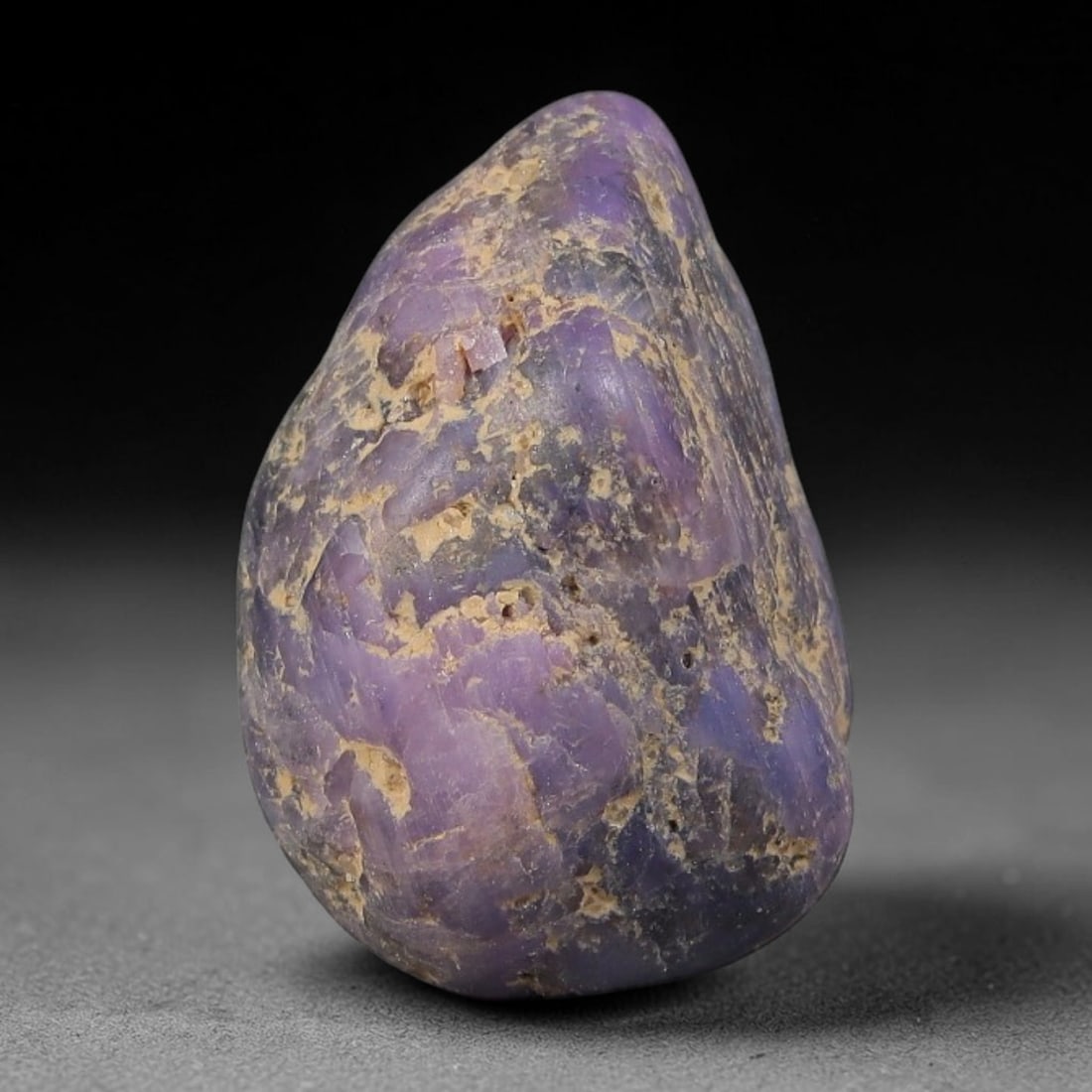 24ct Natural Unheated Sri Lankan Purplish Blue Sapphire Rough, 34YQ: This natural corundum rough is an unheated purplish blue sapphire sourced from Sri Lankan alluvial gem deposits, featuring an irregular natural native form with residual pale yellow-brown mineral matr