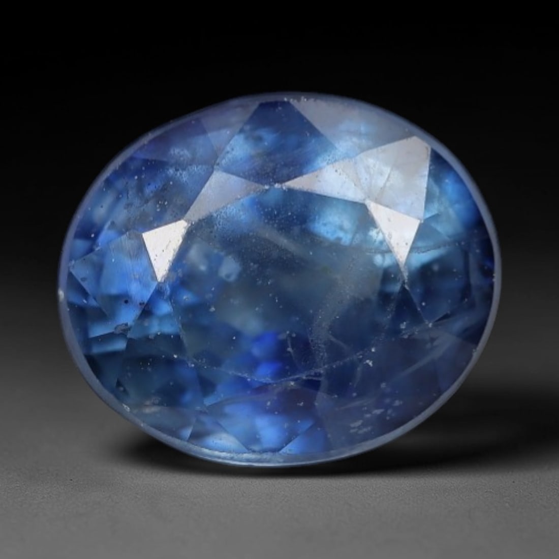 1.15ct Natural Soft Sky Blue Oval Sapphire Loose Faceted Gemstone, LZ309: This natural oval faceted sapphire weighs 1.15 carats with precise dimensions of 6.1x5.2x3.7mm. It carries a gentle airy sky-blue primary hue, mixed with pale translucent grey-blue veiling and vibrant