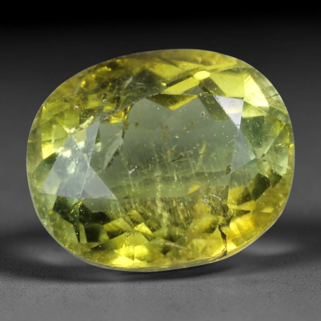 1.11 Carats Yellow-Green Tourmaline Oval - Natural Brazilian Stone, 41XC: This vivid oval-cut tourmaline radiates a striking yellow-green hue, evoking the warm glow of sunlit foliage. The stone's faceted cut creates lively light play, revealing subtle color gradients and a 