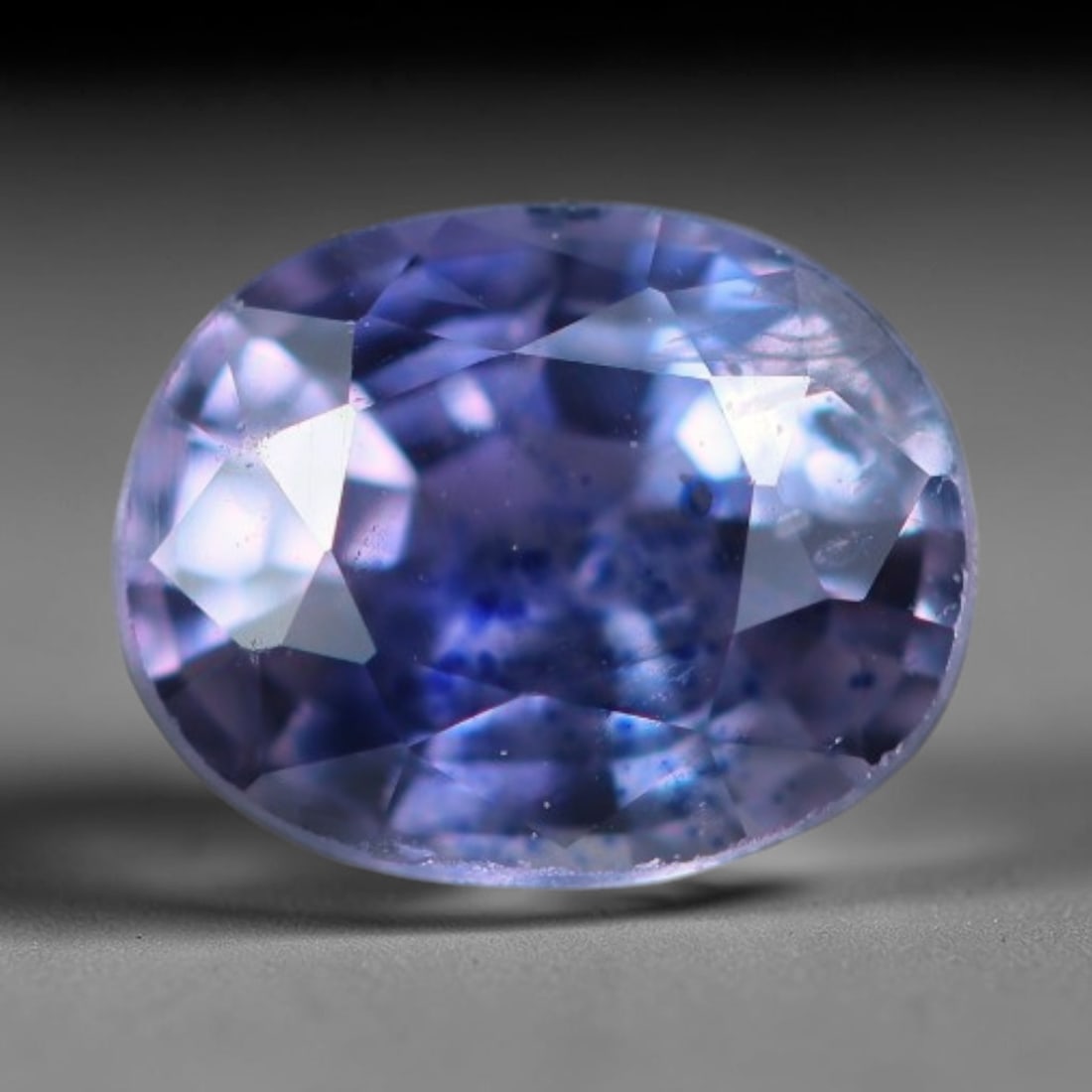 0.65 Carats Natural Violet Blue Sapphire Oval Faceted Loose Gemstone, 80XV: Natural violet-blue corundum sapphire precision cut into an oval faceted loose gemstone, crafted with mixed brilliant facets to deepen color saturation and light refraction. The crystal carries a rich
