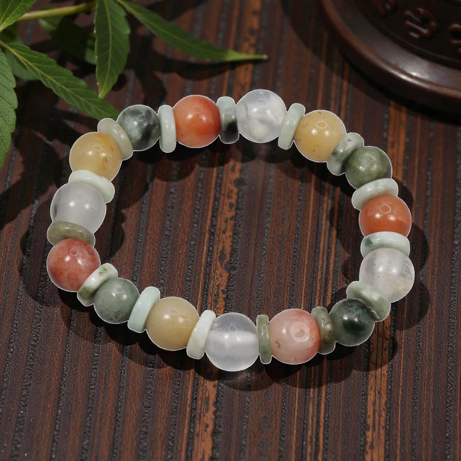 Natural Burmese Type A Jadeite Multicolour Round Bead Bracelet, 43ZK: A meticulously hand-strung bracelet constructed from polished spherical natural Burmese Type A jadeite beads, spaced with thin flat jadeite spacer discs between each round bead. This piece boasts a va