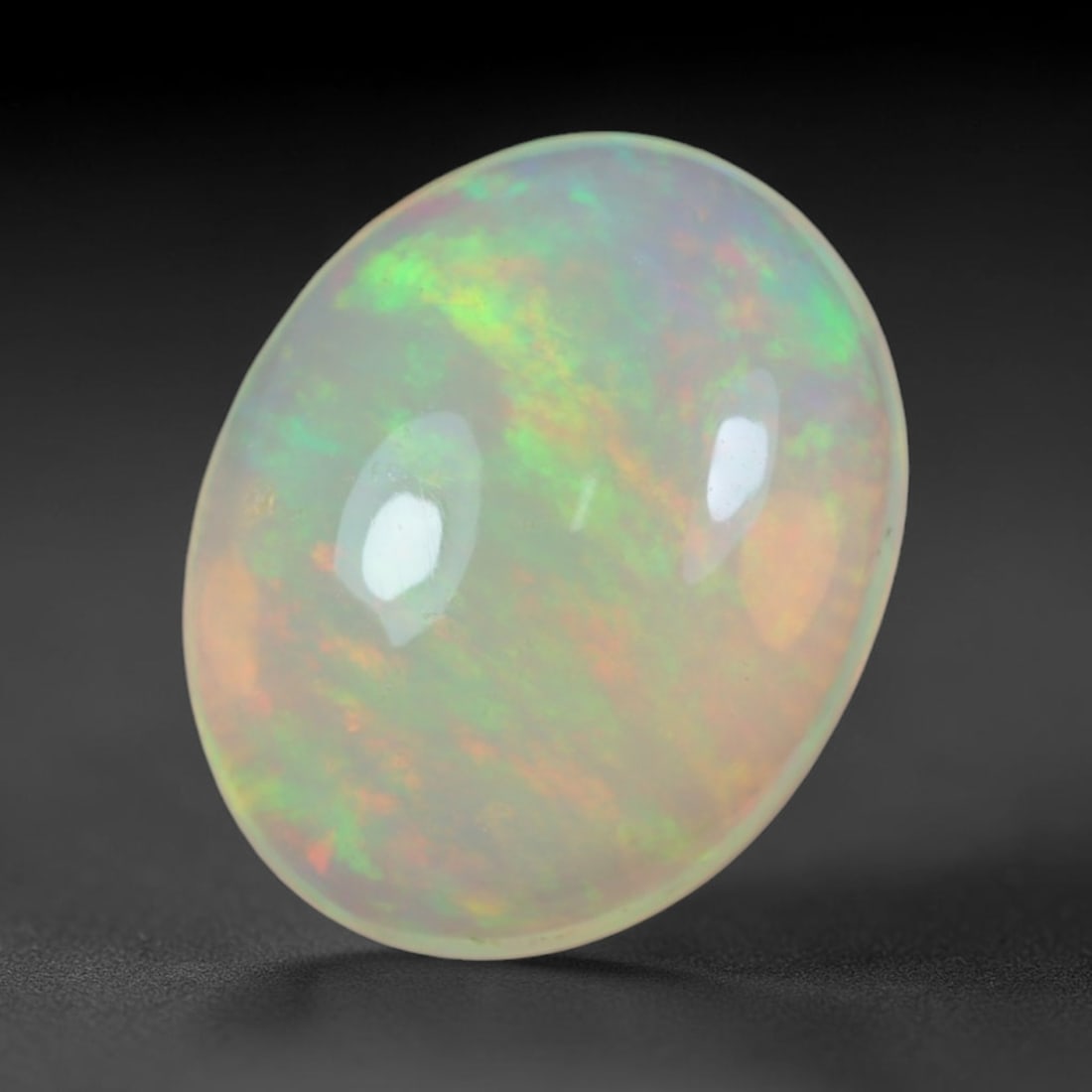 2.00 Carats Natural Ethiopian Welo Opal Oval Cabochon Loose Gemstone, 46XV: Natural Ethiopian Welo opal polished oval cabochon loose gemstone, luminous translucent milky white base stone with vivid multi-hued play-of-color featuring bright emerald green, lime yellow, soft blu