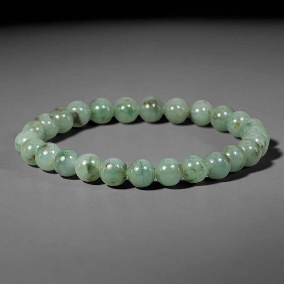 Natural Burmese Type A Green Floating Jadeite Jade Beaded Bracelet, 43WY: Formed from natural untreated Burmese Type A jadeite material, each spherical bead bears naturally dispersed green mineral markings embedded within the stone matrix through geological formation proces