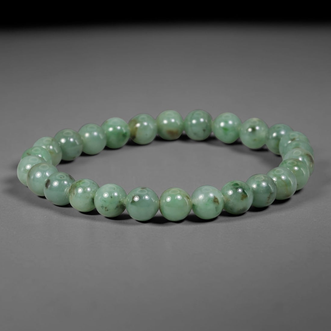Natural Burmese Type A Green Floating Jadeite Jade Beaded Bracelet, 38WY: Formed from natural untreated Burmese Type A jadeite material, each spherical bead bears naturally dispersed green mineral markings embedded within the stone matrix through geological formation proces