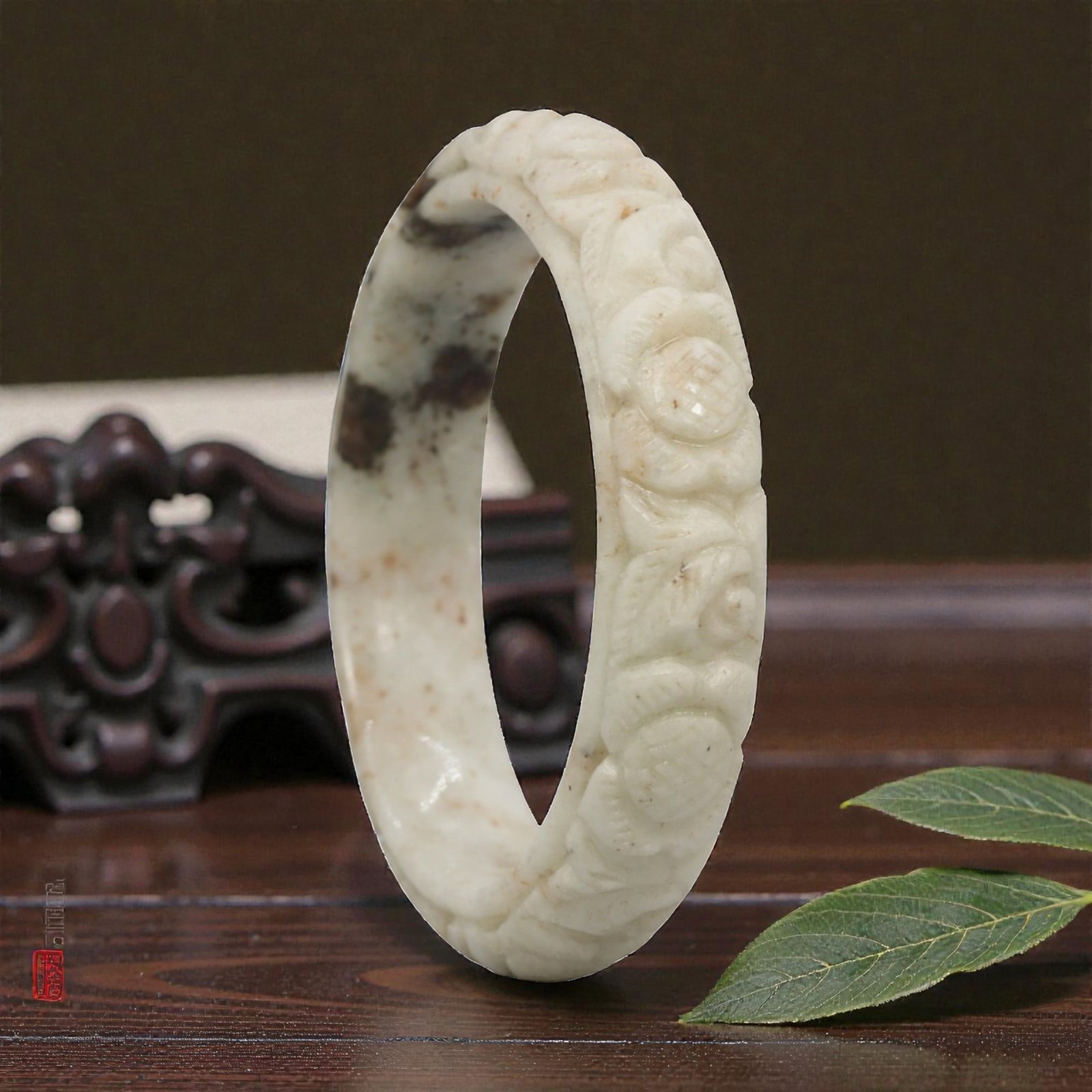 Natural Burmese Type A Carved Jadeite Jade Bangle Bracelet, 20ZL: A fine jadeite bangle of flattened circular form, masterfully carved in relief with a continuous band of floral blossoms and scrolling foliate motifs. The stone exhibits a creamy white base, heavily a