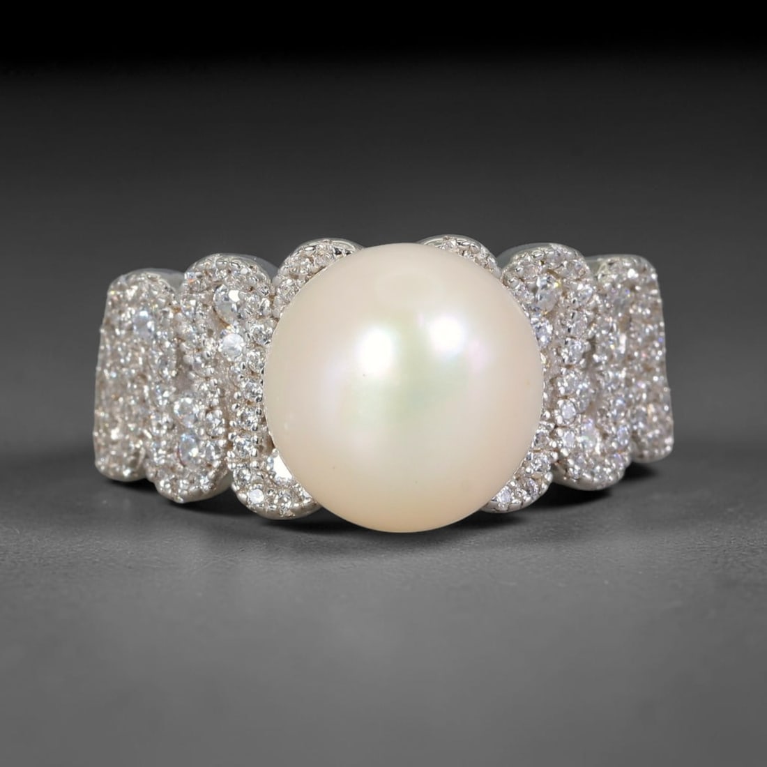 32.28 Carats Adjustable White Pearl & Paved CZ Statement Band Ring, 100YG: Elegant wide band statement ring centered with a large smooth creamy white pearl measuring 11x10.9mm, boasting soft iridescent nacre with subtle blush and pale mint overtones and gentle luminous luste