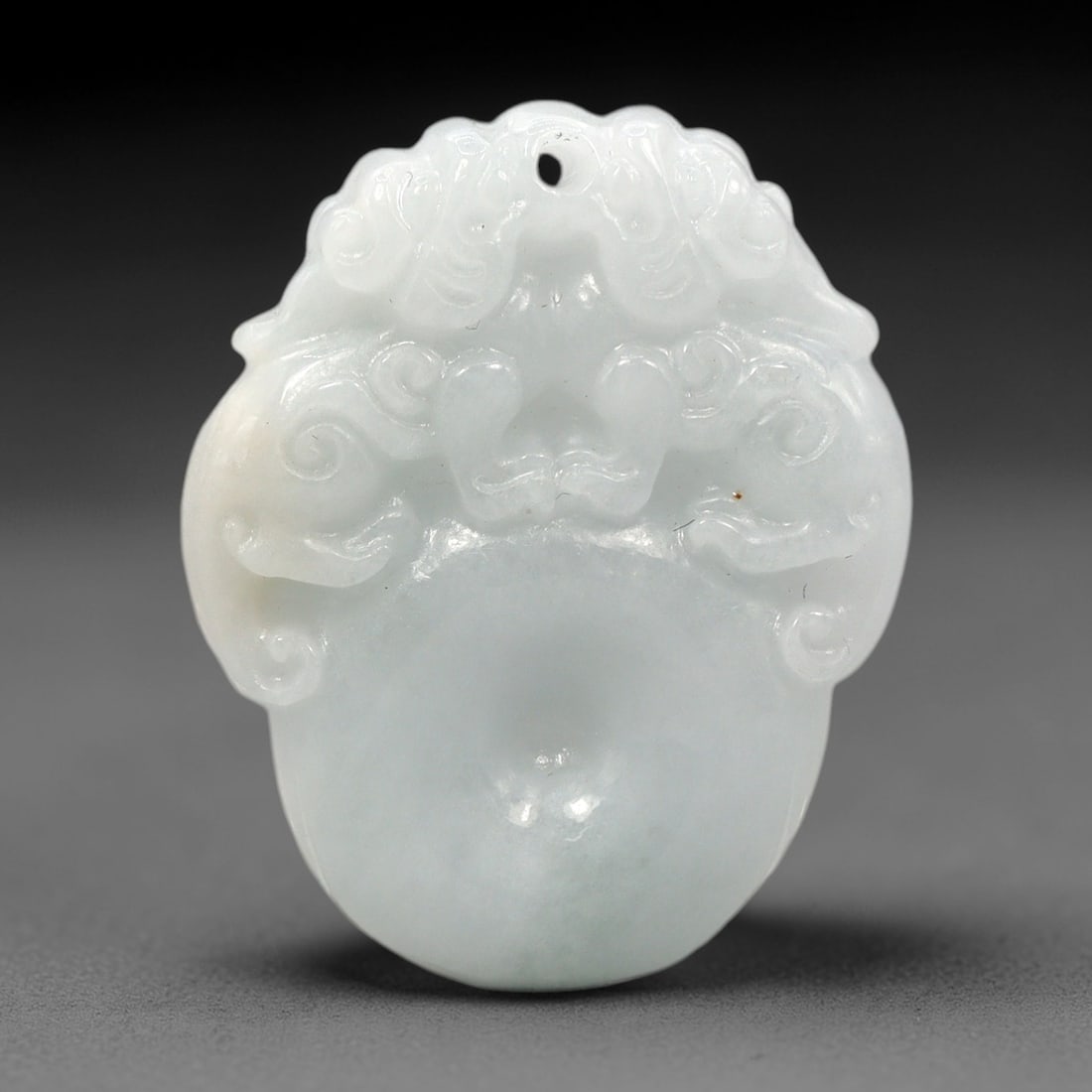Natural Burmese Type A Jadeite Jade - Carved Pendant, 1XM: Fashioned from natural Type A Burmese jadeite with soft milky white mineral tone and subtle translucent crystalline matrix, this polished pendant features intricate raised scroll carving across its up