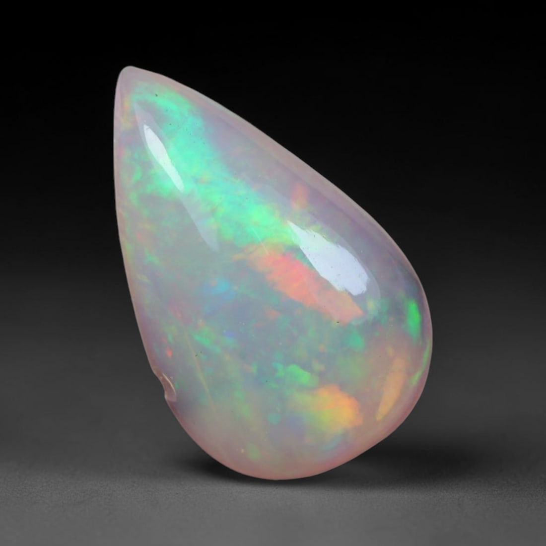 1.48 Carats Natural Ethiopian Welo Opal Oval Cabochon Loose Gemstone, 40XV: Natural Ethiopian Welo opal polished oval cabochon loose gemstone, luminous translucent milky white base stone with vivid multi-hued play-of-color featuring bright emerald green, lime yellow, soft blu