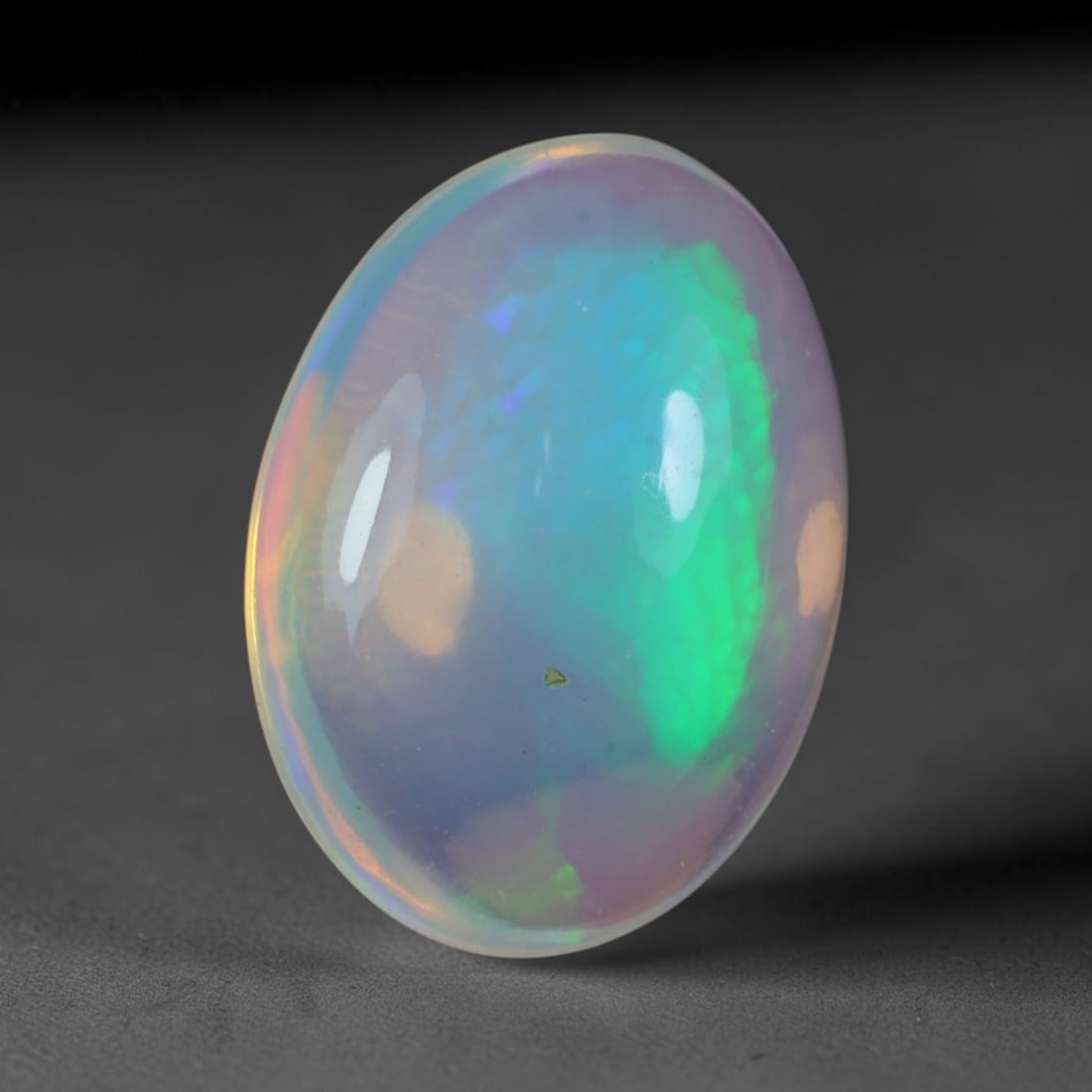 3.47 Carats Natural Ethiopian Welo Opal Oval Cabochon Loose Gemstone, 57XV: Natural Ethiopian Welo opal polished oval cabochon loose gemstone, luminous translucent milky white base stone with vivid multi-hued play-of-color featuring bright emerald green, lime yellow, soft blu