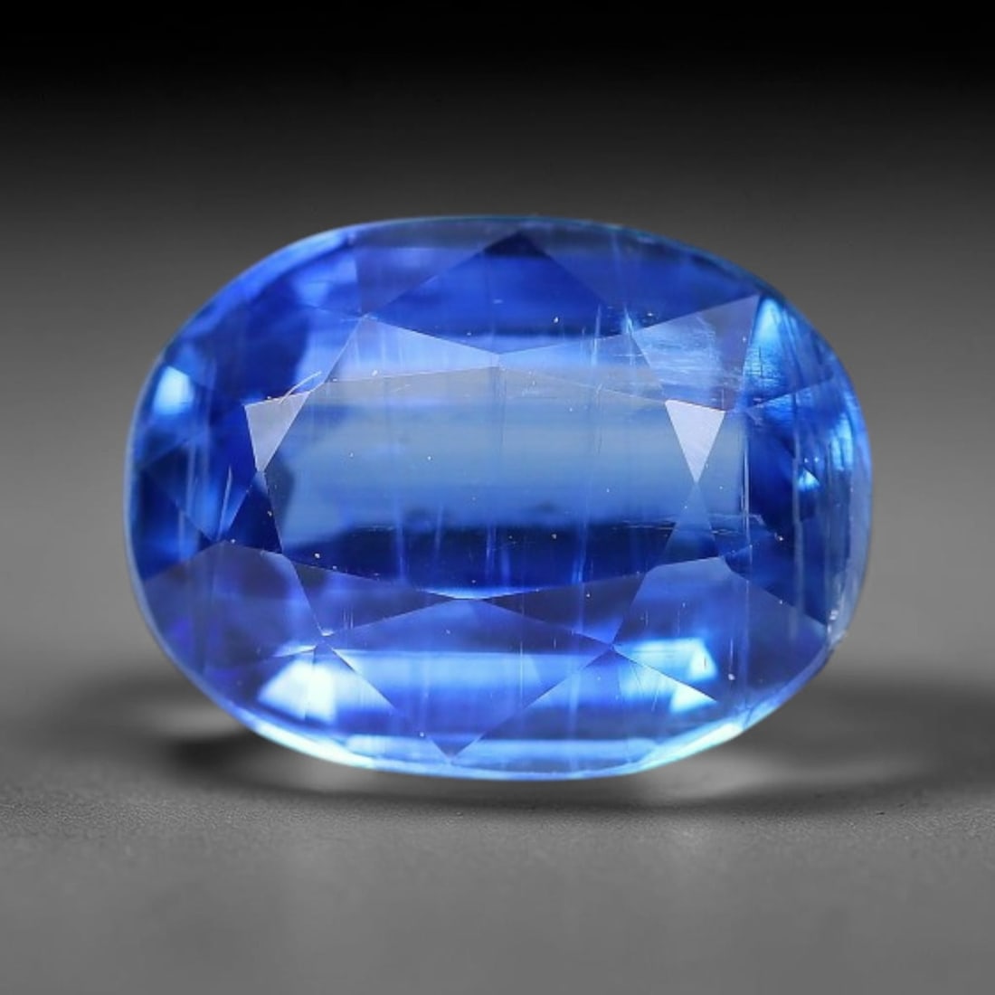 1.97 Carats Natural Brazilian Kyanite Oval Faceted Loose Gemstone, 61XY: This specimen consists of natural kyanite mineral material refined via professional faceted lapidary work, with uniform polished surfaces across the crystal exterior. Natural internal particulate mark