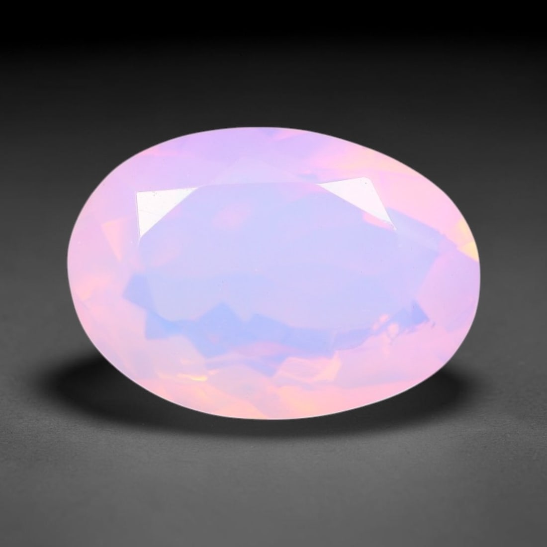 2.25 Carats Natural Ethiopian Welo Pink Fire Opal Oval Faceted Loose Gemstone, 81XX: This opal is sourced from the Welo mining region of Ethiopia and crafted into faceted form via professional lapidary cutting with smooth polished facets across the exterior surface. Subtle natural int