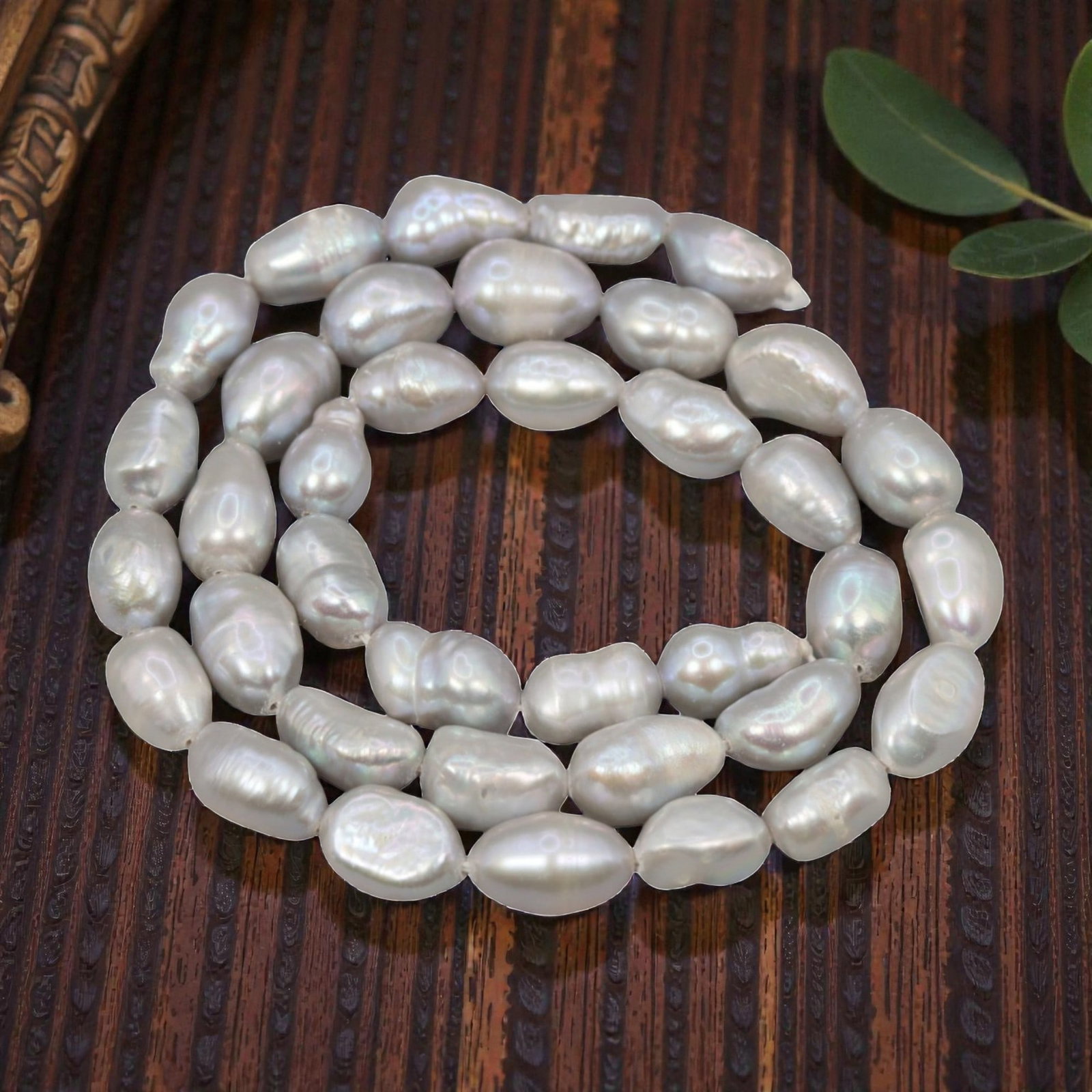 A Strand of Baroque Cultured Pearls, 20th Century, 82ZJ: Composed of baroque cultured pearls with a silvery-white body color and strong iridescent overtones, the strand is strung in a single continuous line. Each pearl exhibits an irregular, elongated shape