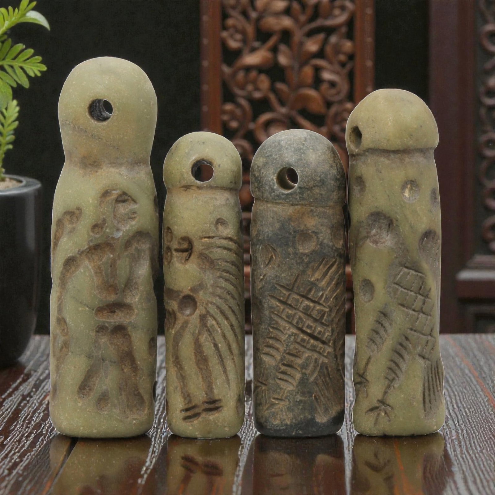 A Lot of 4 Ancient Mesopotamian Serpentine Cylinder Seals, 46WP: A curated lot of four ancient Mesopotamian-style cylinder seals, carved from serpentine stone with natural patination and wear consistent with age. Each seal features a domed top with a suspension hol