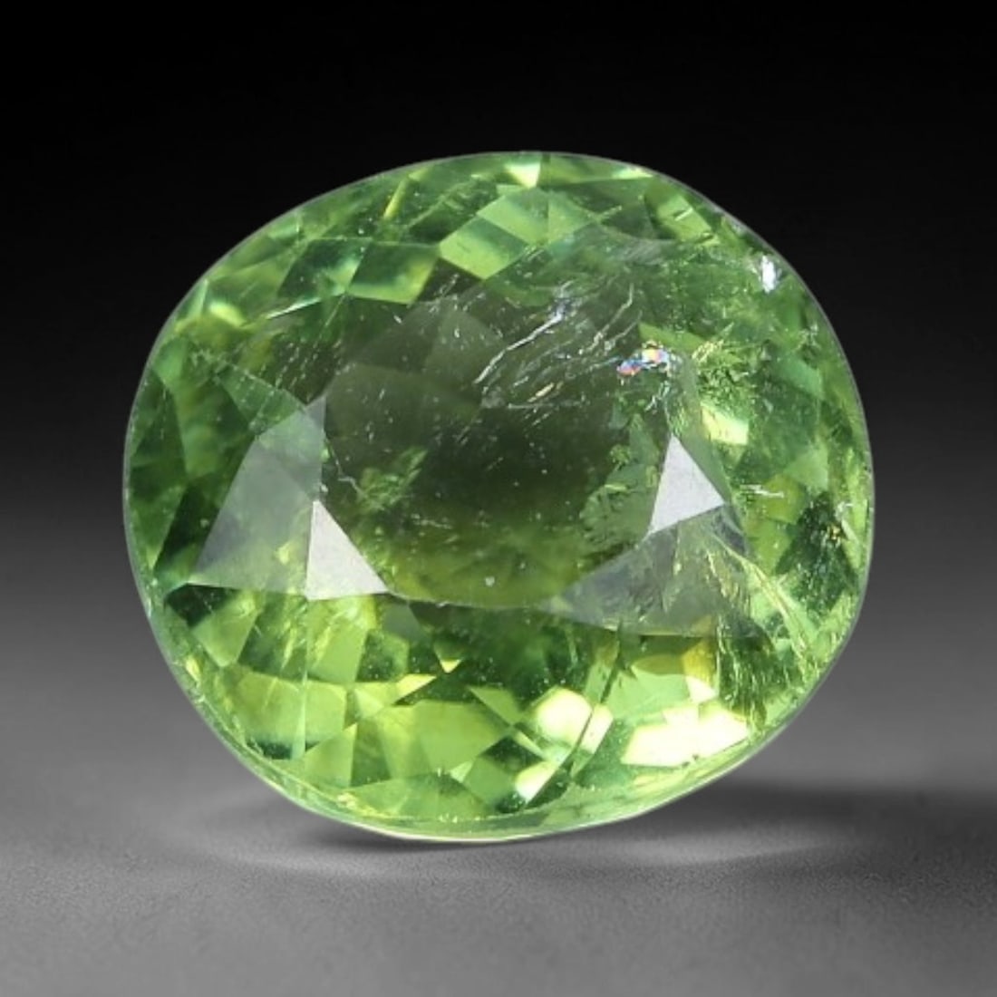 1.40 Carats Bright Lime Green Tourmaline Oval Cut - Natural Loose Gemstone, 46XC: This vibrant oval-cut tourmaline glows with a saturated, bright lime-green hue, reminiscent of fresh citrus or sunlit spring foliage. Its precision faceting creates a brilliant play of light, with sub