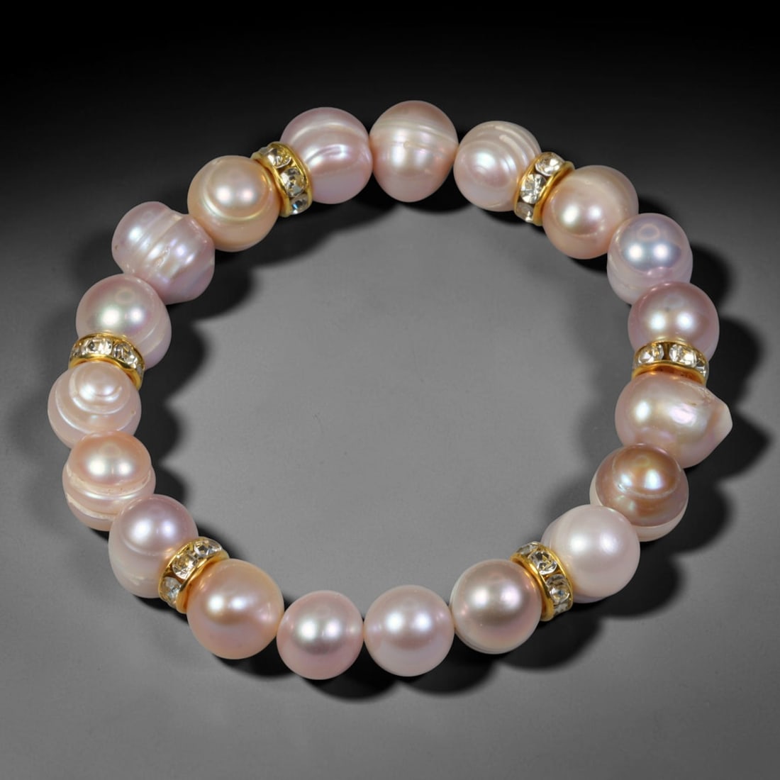 Natural Freshwater Pearl Beaded Bracelet - 10mm Baroque Pearl Strand, 44YM: This elastic stretch bracelet is strung with 10mm natural freshwater baroque pearls, separated by gold-toned metal spacers set with clear crystalline accents. Each pearl features organic irregular nat