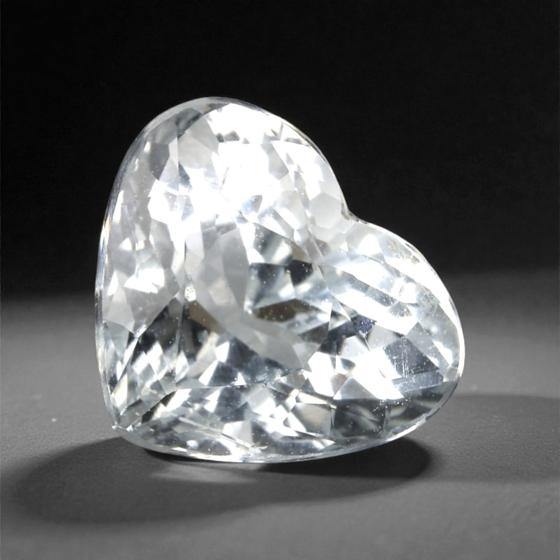 1.84 Carats Light Blue Brazilian Aquamarine Heart Cut , 64XK: This charming aquamarine displays a clear, icy light blue color with a crisp, luminous appearance that reflects light with bright, watery flashes. The heart cut gives the stone a graceful and romantic