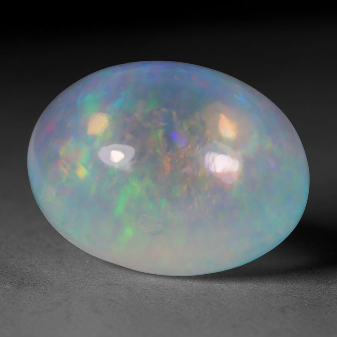 7.07 Carats Natural Ethiopian Welo Pastel Oval Cabochon Opal Loose Gemstone, 97WS: This generously sized domed oval cabochon Ethiopian Welo opal features a milky translucent pale blue-white base, adorned with sprawling multi-tonal play-of-color including soft lime green, golden yell