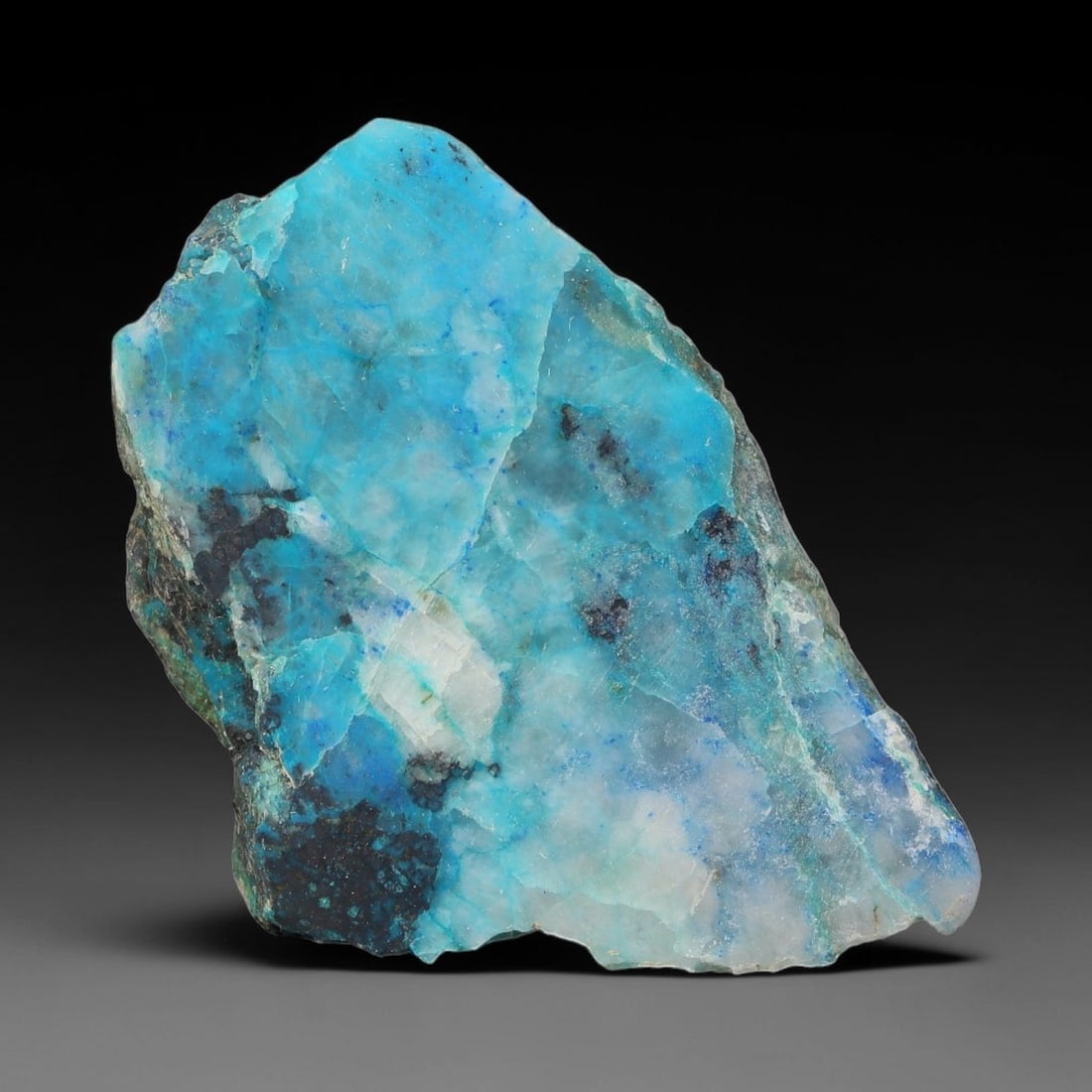 85ct Natural Peruvian Chrysocolla Polished Slab Rough, 37WV: This partial-polished chrysocolla slab features blended mineral matrix with smooth refined face and unaltered natural rugged edge across its 41x27x9mm elongated form, translucent mineral layers hold s