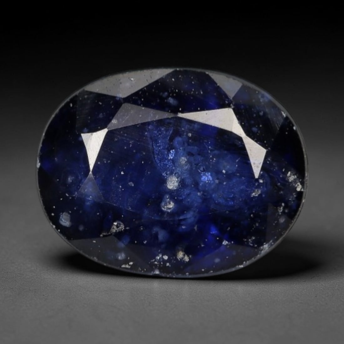 1.03ct Natural Deep Royal Blue Sapphire Oval Loose Faceted Gemstone, LZ302: This natural oval faceted sapphire weighs 1.03 carats with precise dimensions of 6.6x5.0x3.3mm. It features an intense deep royal navy blue core, surrounded by semi-translucent cool grey-blue outer fa