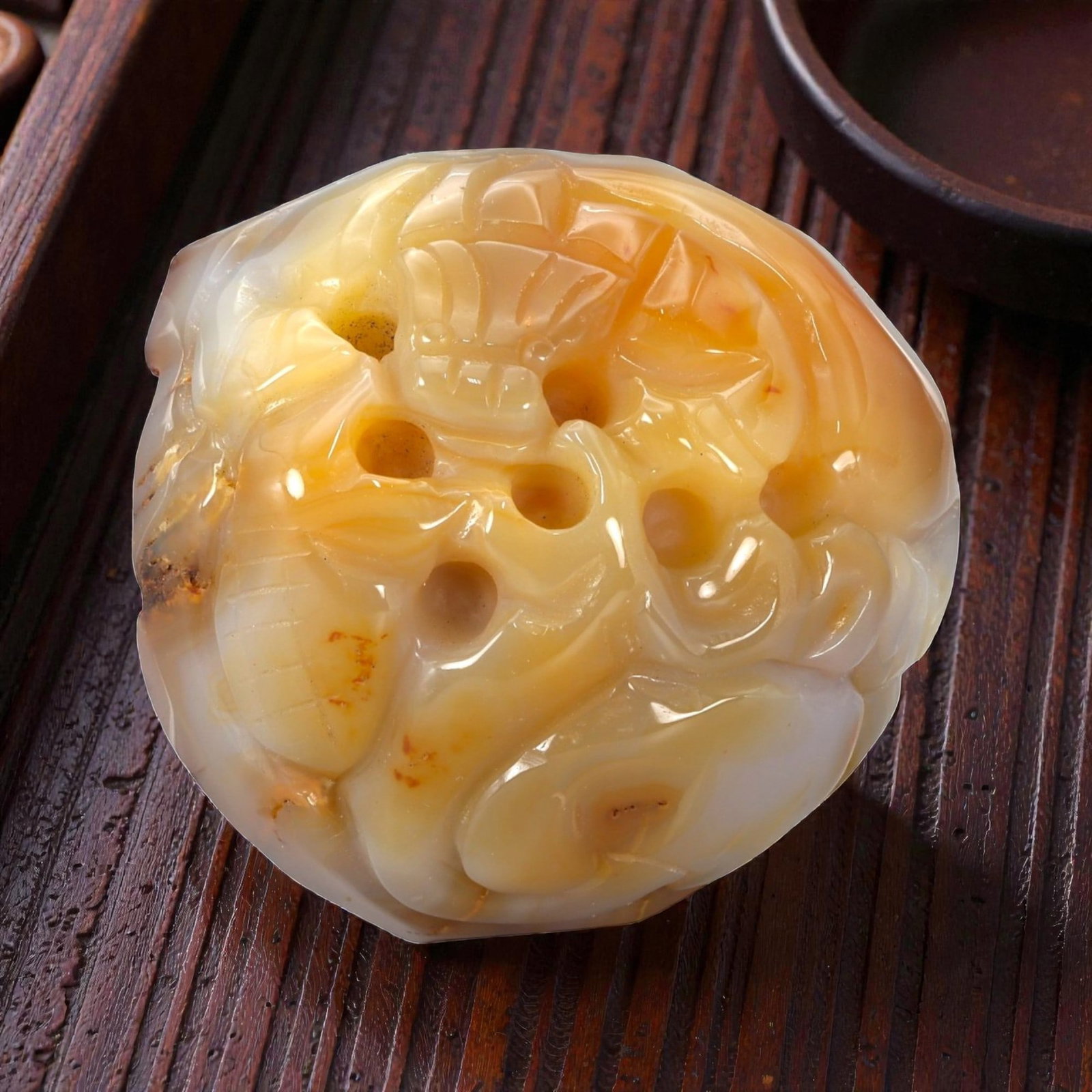 A Chinese Chalcedony Pebble Carving, 20th Century, 20YB: Carved from translucent chalcedony displaying natural white and honey-toned banding with areas of iron-oxide staining, the object is worked from a rounded pebble form retaining its organic outline. Th