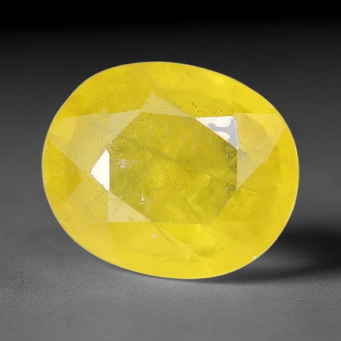 1.92 Carats Natural Yellow Sapphire Oval Faceted Loose Gemstone, 86XM: This natural yellow sapphire features a classic oval brilliant faceted cut, holding consistent warm golden-yellow color throughout the corundum crystal. Fine microscopic mineral specks and faint natur