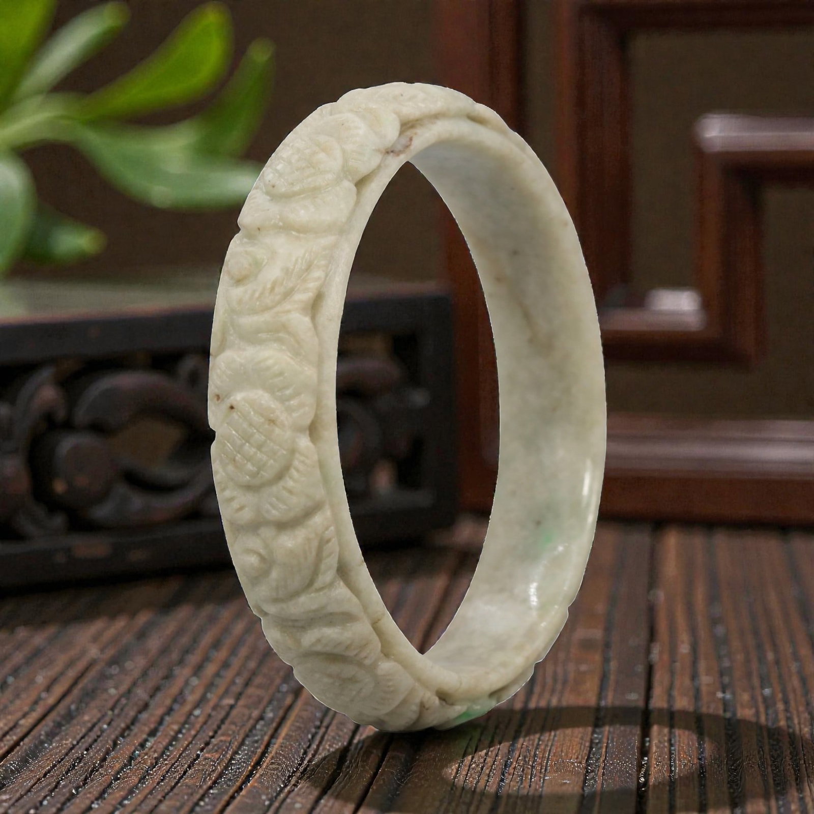 Natural Burmese Type A Carved Jadeite Jade Bangle Bracelet, 28ZL: A fine jadeite bangle of flattened circular form, masterfully carved in relief with a continuous band of peony blossoms and interlocking foliate motifs. The stone features a predominantly creamy white