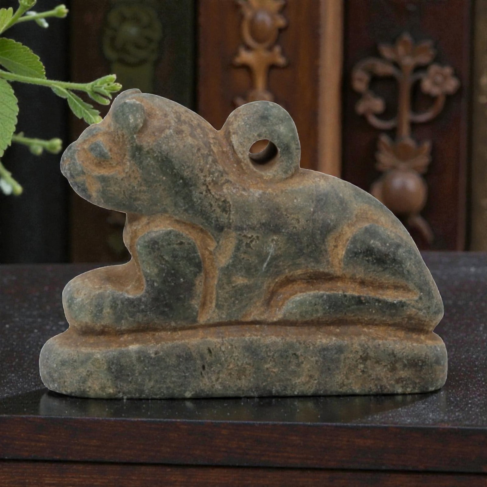 Ancient Near Eastern Style Stone Recumbent Feline Amulet, 82WM: A single ancient Near Eastern-style stone amulet, carved in the form of a recumbent feline (likely a lion) on a rectangular base. The piece features simplified facial features, stylized limbs, and a s