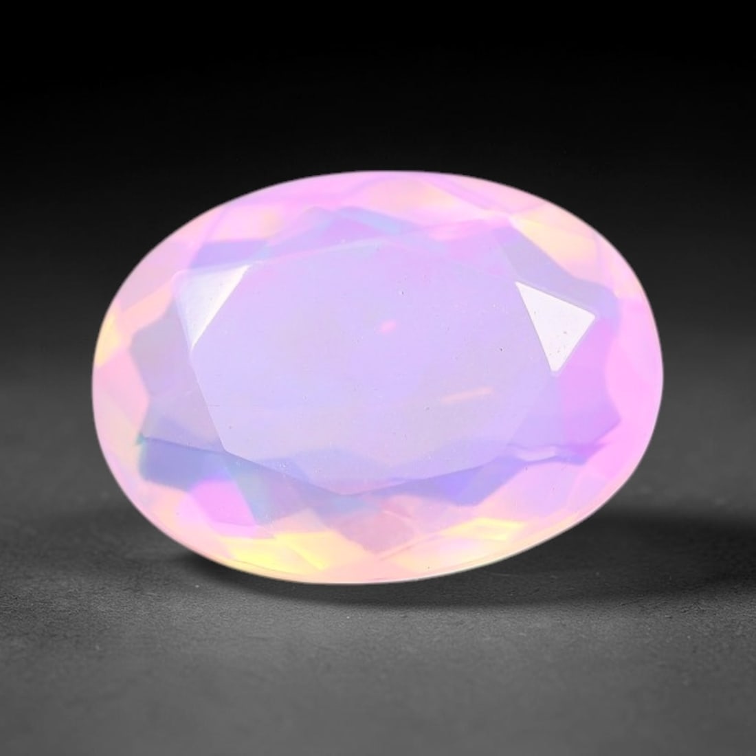 1.28 Carats Natural Ethiopian Welo Pink Fire Opal Oval Faceted Loose Gemstone, 77XX: This opal is sourced from the Welo mining region of Ethiopia and crafted into faceted form via professional lapidary cutting with smooth polished facets across the exterior surface. Subtle natural int