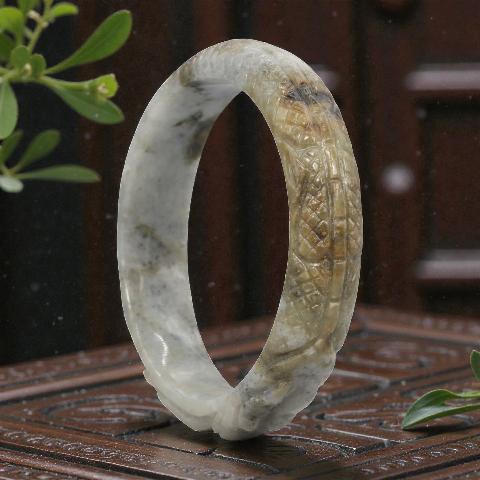 Natural Burmese Type A Carved Jadeite Jade Bangle Bracelet, 30ZL: A fine jadeite bangle of circular form, masterfully carved in relief with a continuous band of a sinuous dragon coiling around its circumference. The stone exhibits a striking variegated palette, with