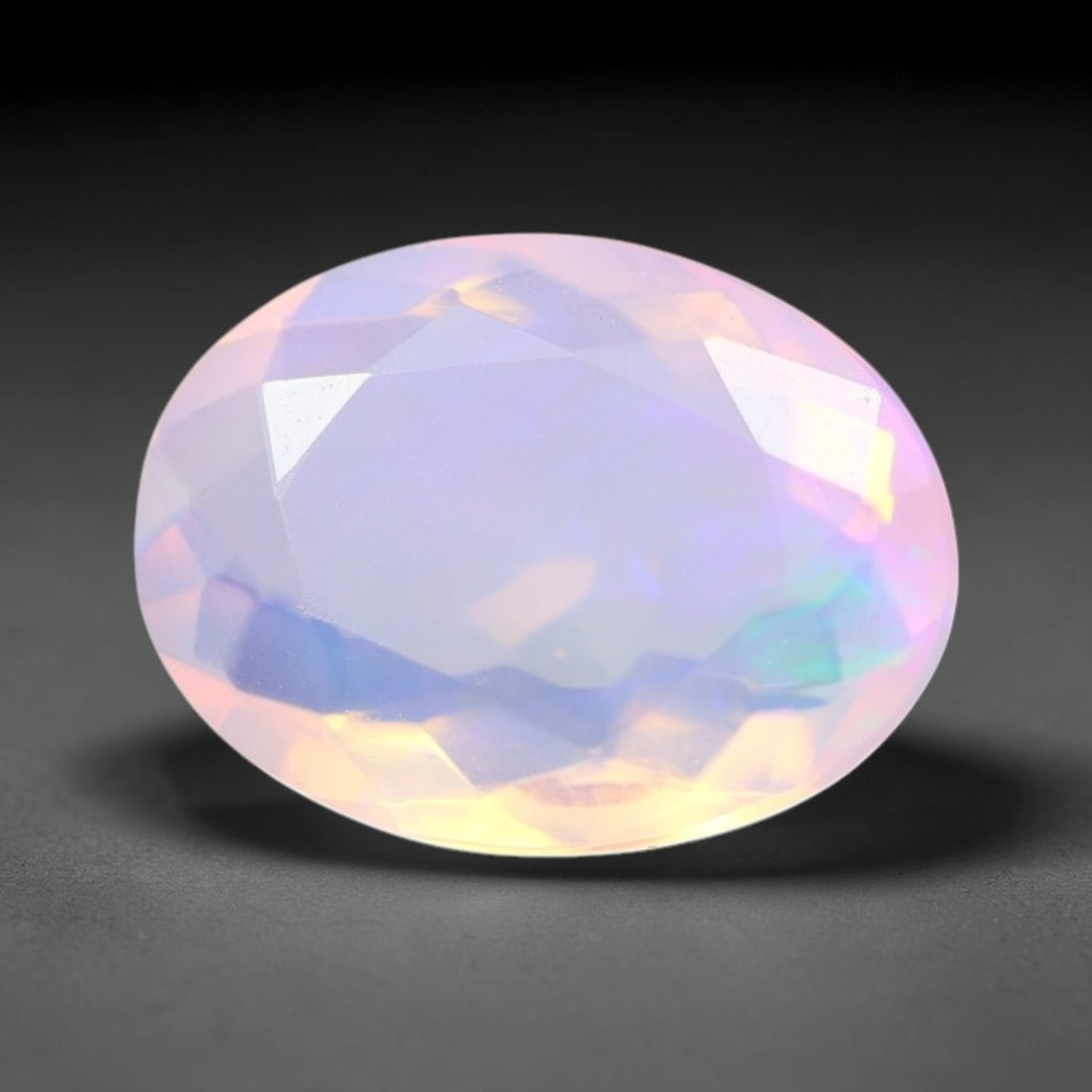 2.31 Carats Natural Ethiopian Welo Pink Fire Opal Oval Faceted Loose Gemstone, 82XX: This opal is sourced from the Welo mining region of Ethiopia and crafted into faceted form via professional lapidary cutting with smooth polished facets across the exterior surface. Subtle natural int