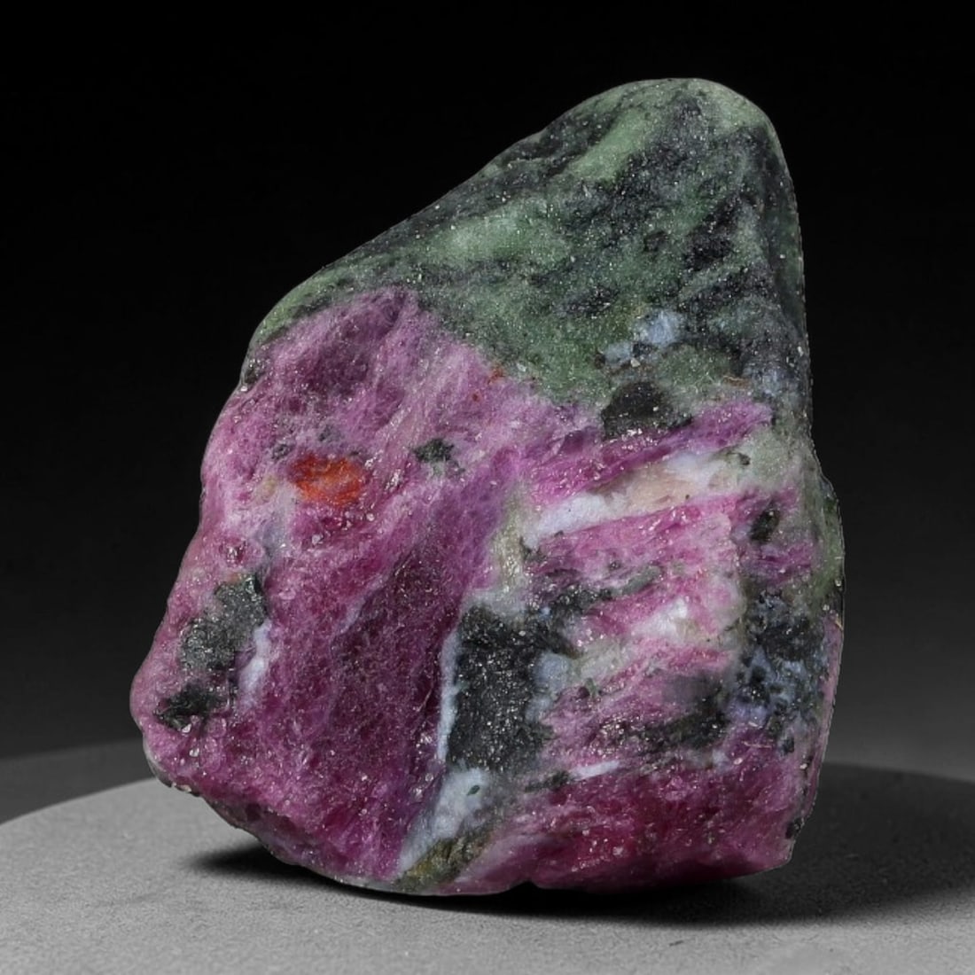 66ct Natural Tanzanian Ruby Zoisite Raw Rough Specimen Mineral Stone, 98YK: This unpolished mineral rough is natural ruby zoisite sourced from Tanzania, exhibiting distinct banded mineral segregation of vibrant green zoisite, magenta ruby crystals, and dark hornblende inclusi