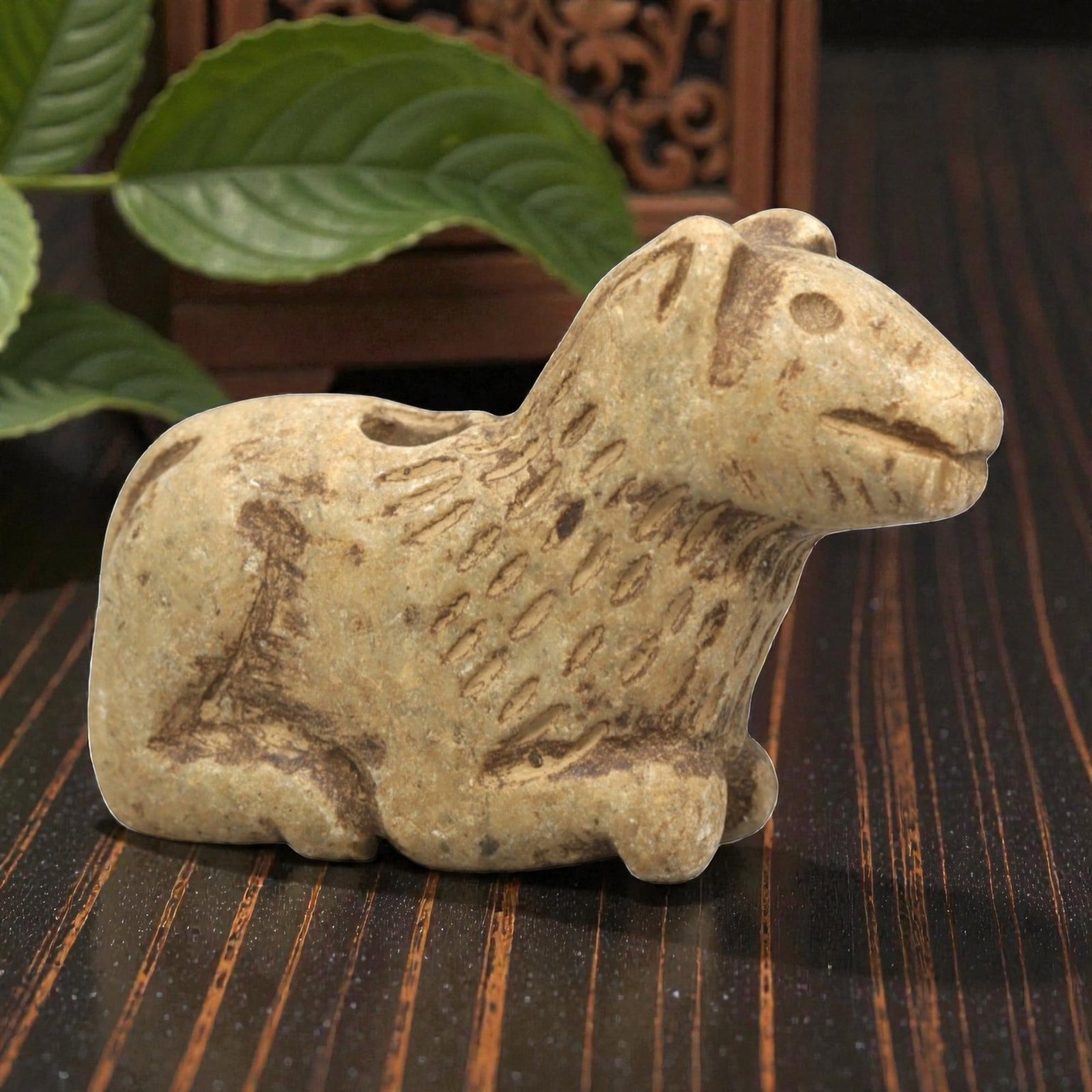 Ancient Stone Canine Figurine - Near Eastern Ritual Relics, 95ZP: Carved from warm tan stone, this reclining canine figurine features a stylized head with incised eyes, pointed ears, and a gently curved mouth. The neck and upper body display textured, linear incisio