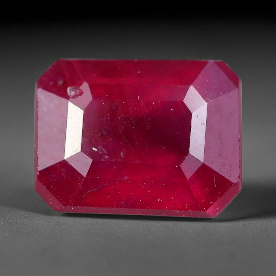2.33 Carats Natural Madagascar Ruby Emerald Cut Loose Gemstone, 67XM: This natural Madagascar ruby is fashioned in a traditional emerald step faceted cut, showcasing deep saturated red tones typical of Malagasy corundum. Distinct natural internal fissures, fine mineral 