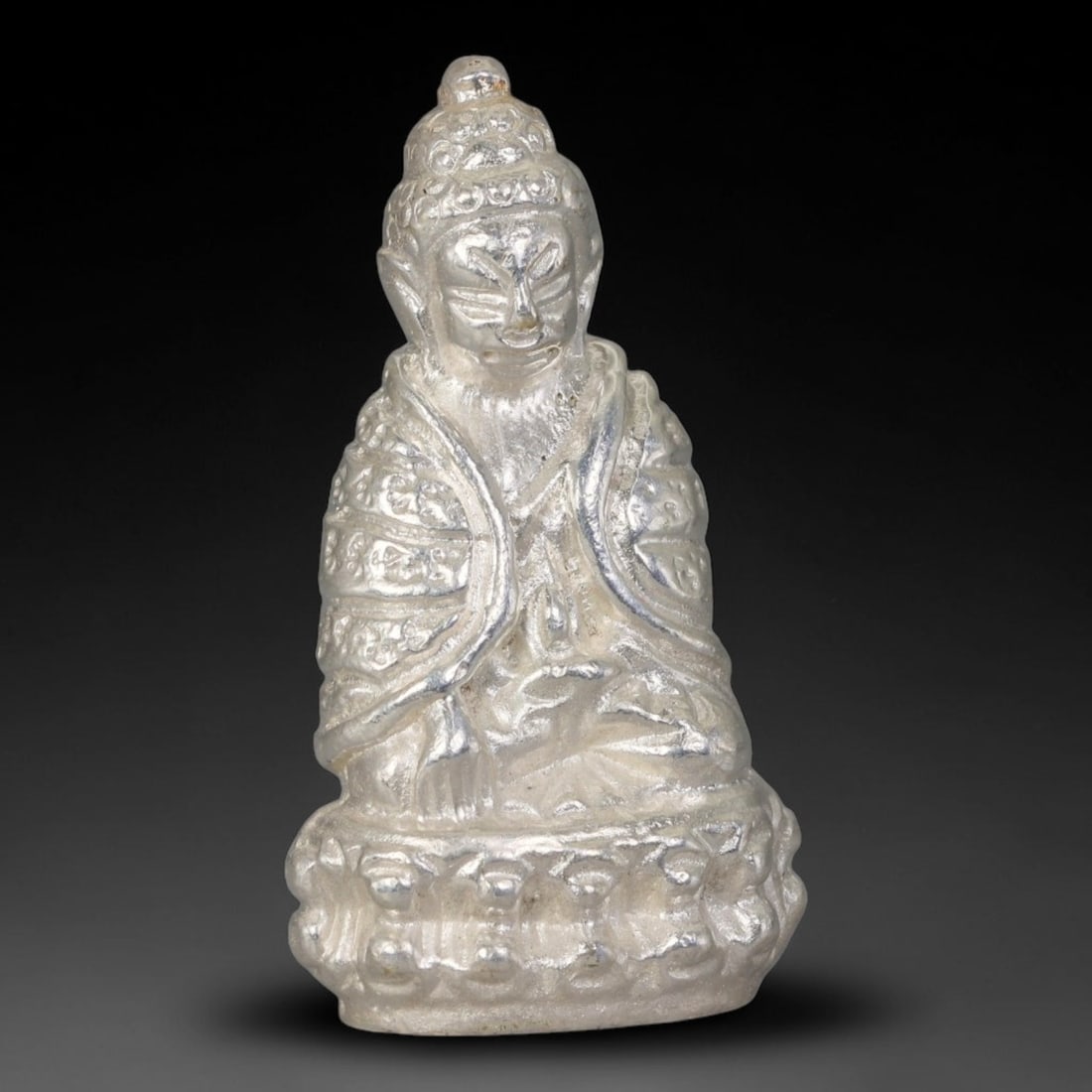 Thai Silver Tone Metal Mini Sacred Statuette Amulet, 79ZB: Small cast metal sacred figurine with elaborate embossed textures covering the robe, cranial detailing and layered pedestal base. Faint surface wear and subtle patina marks appear on raised sculpted a