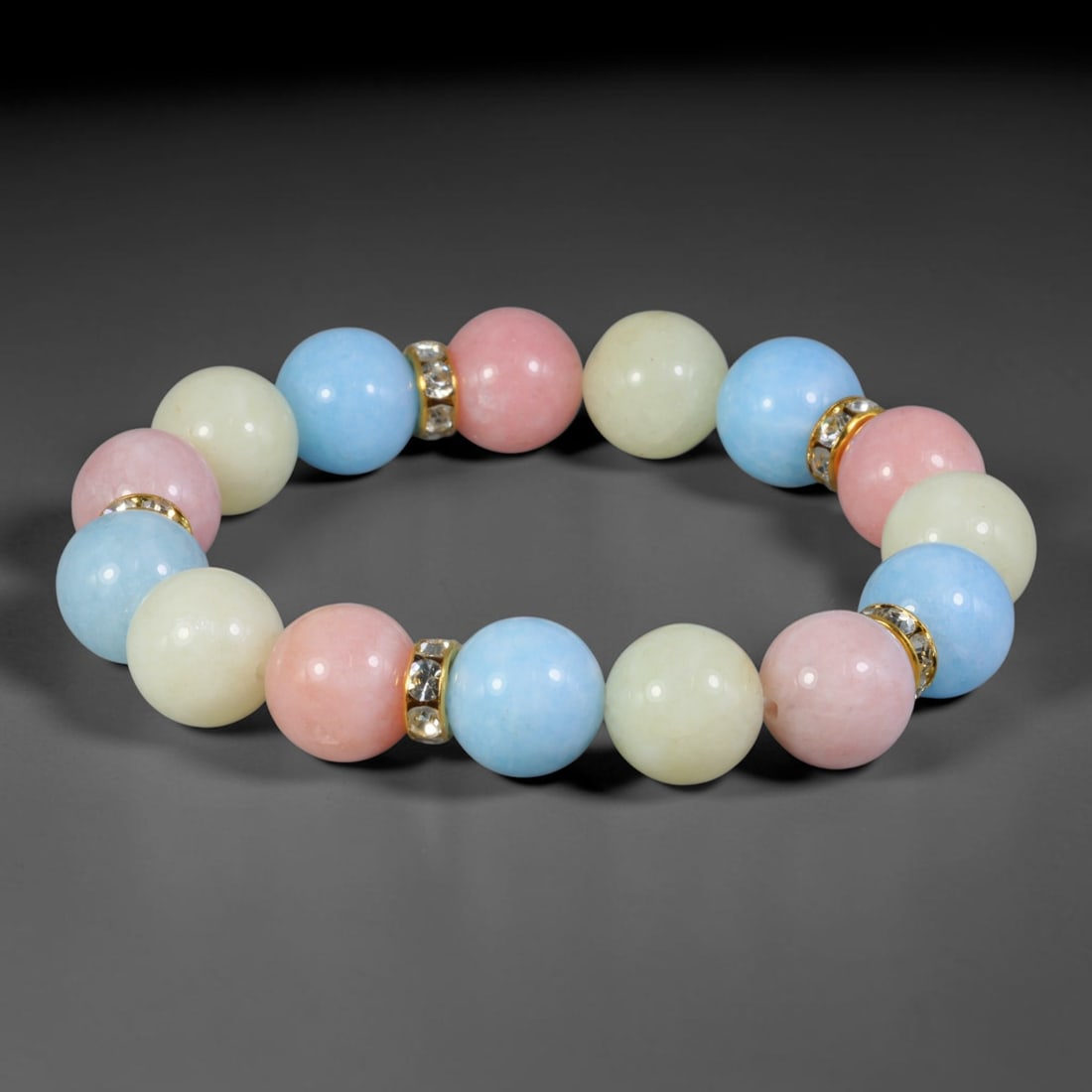 Natural Mixed Stone Beaded Bracelet - Polished Round Bead Strand, 32YM: This elastic stretch bracelet is constructed from uniformly spherical polished natural mineral beads separated by gold-toned metal spacers set with clear crystalline accents. The hard stone displays s