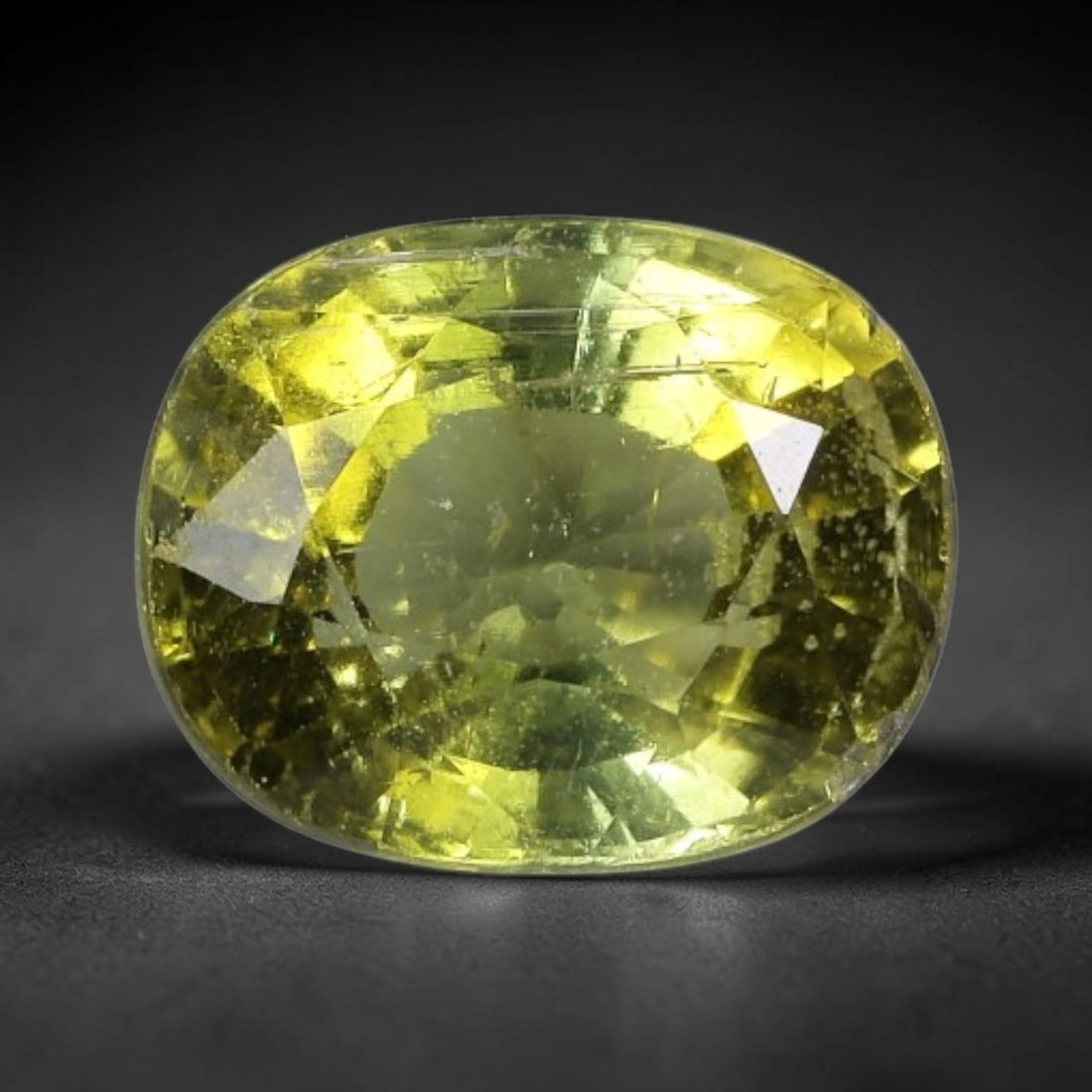 1.52 Carats Golden Yellow-Green Tourmaline Oval Cut - Natural Loose Gemstone, 67XC: This vibrant oval-cut tourmaline features a warm golden yellow-green hue, evoking the glow of sunlight filtering through sunlit foliage. Its faceting creates a lively play of light, with subtle color 