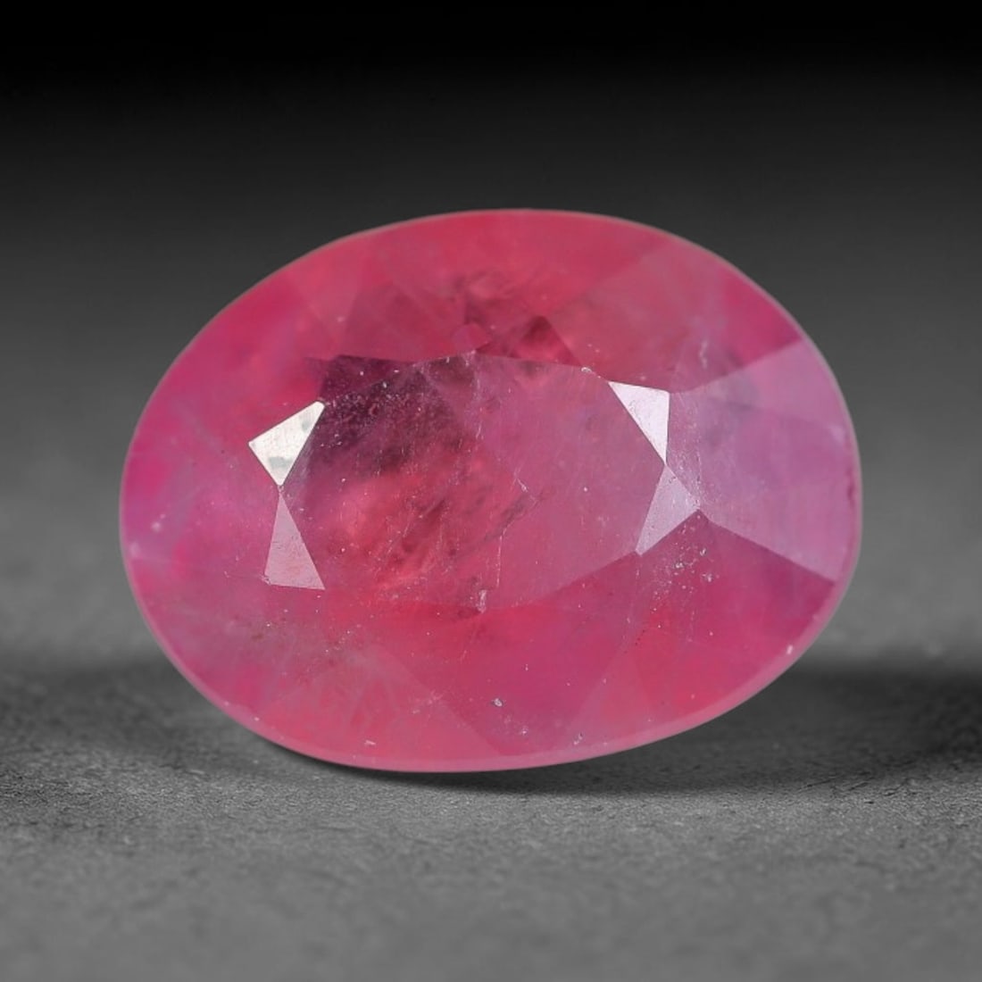 1.50 Carats Natural Orange Sapphire Oval Faceted Loose Gemstone, 95XM: This natural orange sapphire is cut into a balanced oval brilliant faceted form, showcasing soft warm orange-pink hues characteristic of natural corundum material. Fine scattered mineral pinpoints and