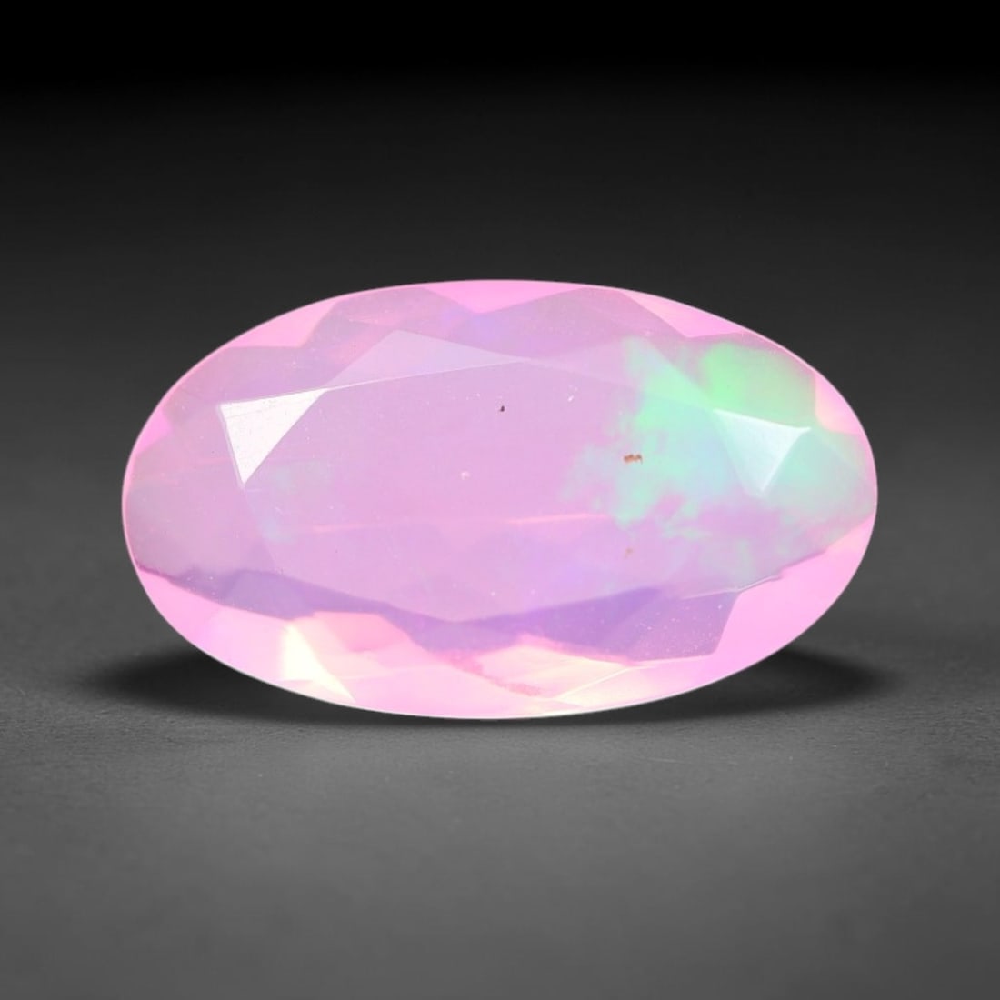 1.70 Carats Natural Ethiopian Welo Pink Fire Opal Oval Faceted Loose Gemstone, 73XX: This opal is sourced from the Welo mining region of Ethiopia and crafted into faceted form via professional lapidary cutting with smooth polished facets across the exterior surface. Subtle natural int