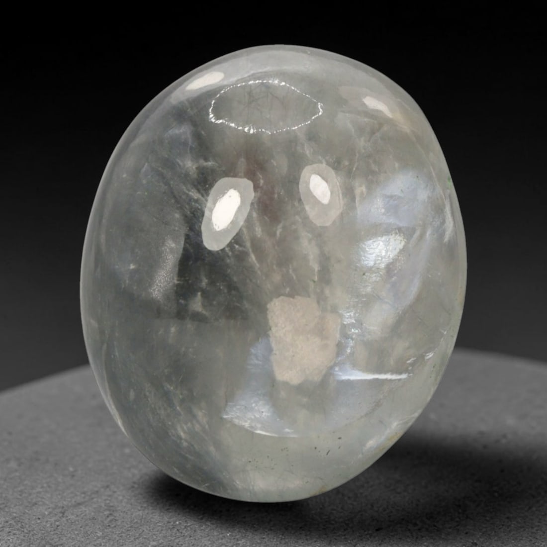 44.63 Carats Phantom Quartz Oval Cabochon - Natural Brazilian Stone, 95XB: This exceptional phantom quartz cabochon, measuring 24.7 x 20.5 x 12.4 mm, is a captivating window into the natural growth of crystal. Polished into a smooth, rounded oval, the stone's translucent, mi