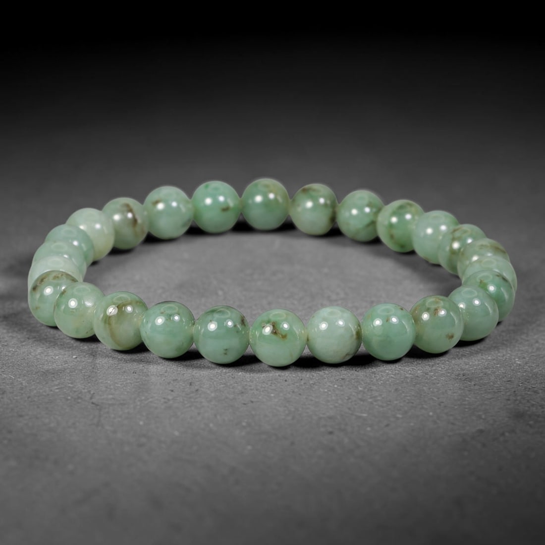 Natural Burmese Type A Green Floating Jadeite Jade Beaded Bracelet, 37WY: Formed from natural untreated Burmese Type A jadeite material, each spherical bead bears naturally dispersed green mineral markings embedded within the stone matrix through geological formation proces
