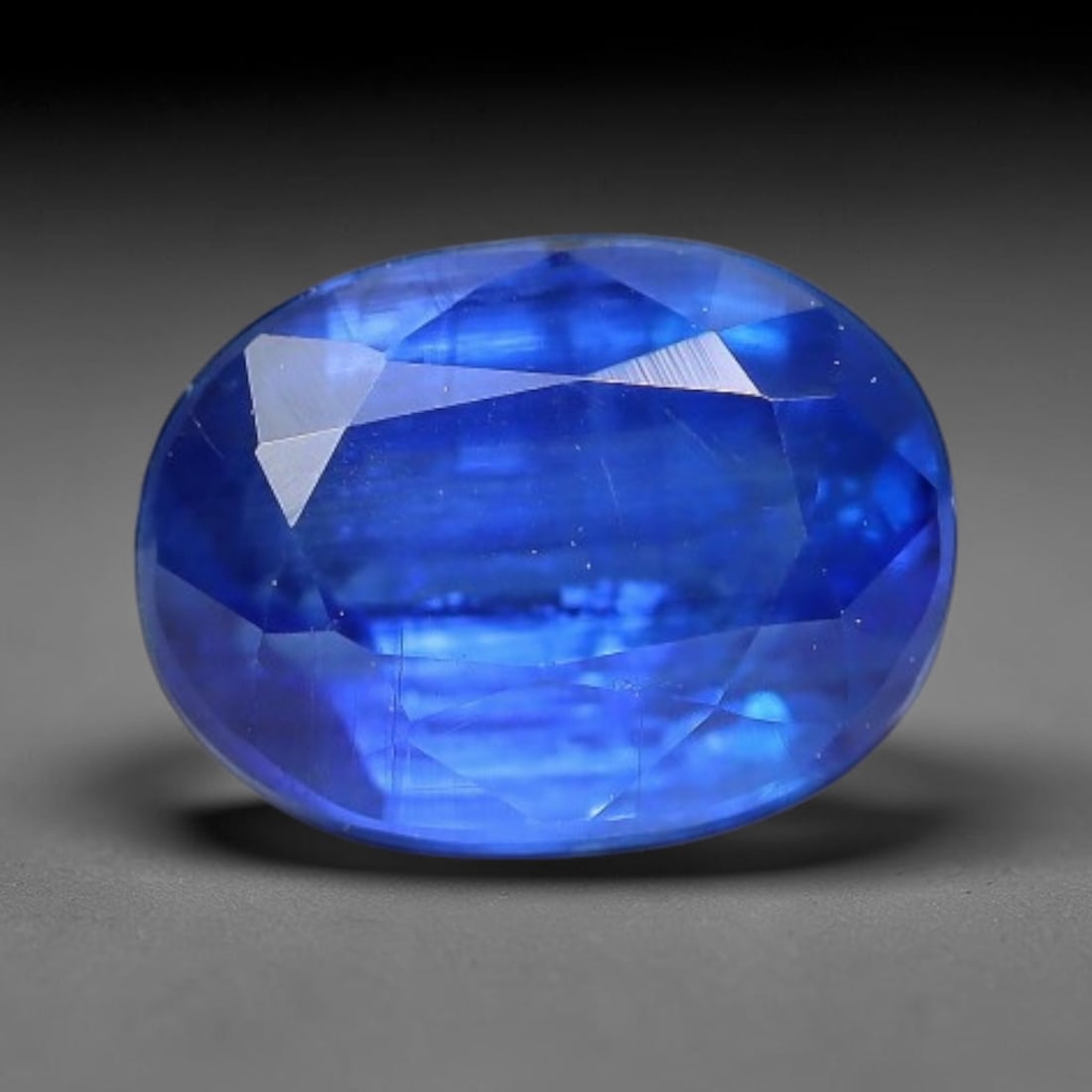 1.93 Carats Natural Brazilian Kyanite Oval Faceted Loose Gemstone, 66XY: This specimen consists of natural kyanite mineral material refined via professional faceted lapidary work, with uniform polished surfaces across the crystal exterior. Natural internal particulate mark