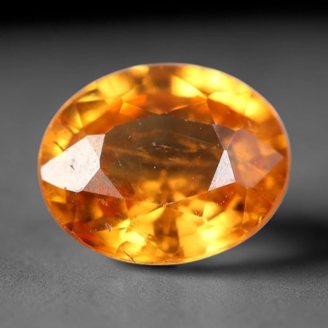 0.53 Carats Natural Golden Orange Yellow Sapphire Oval Faceted Loose Gemstone, 70XV: Natural vibrant golden orange-yellow corundum sapphire precision cut into an oval faceted loose gemstone, fashioned with mixed brilliant facets to intensify warm fiery color saturation and light refle