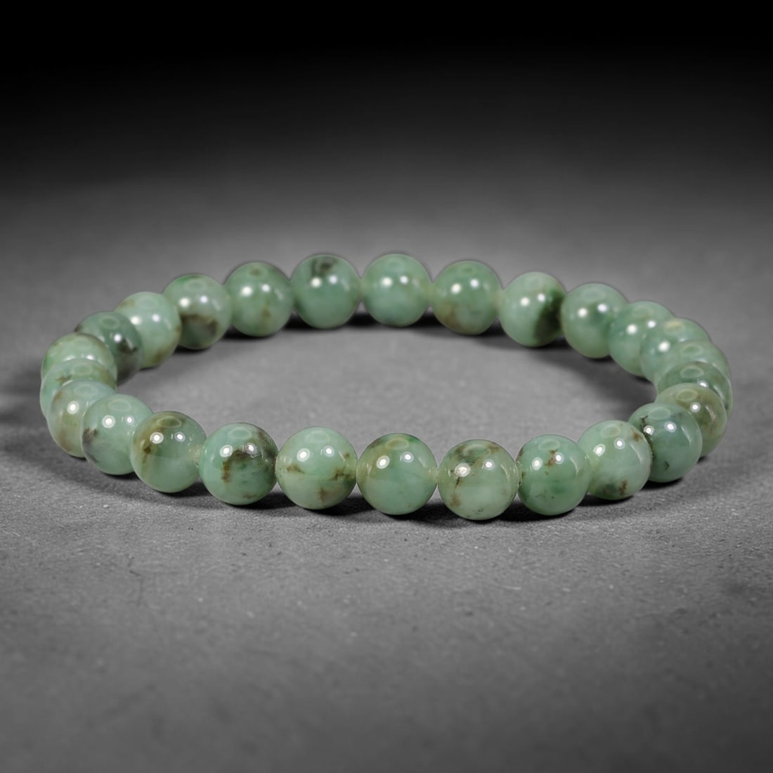 Natural Burmese Type A Green Floating Jadeite Jade Beaded Bracelet, 44WY: Formed from natural untreated Burmese Type A jadeite material, each spherical bead bears naturally dispersed green mineral markings embedded within the stone matrix through geological formation proces
