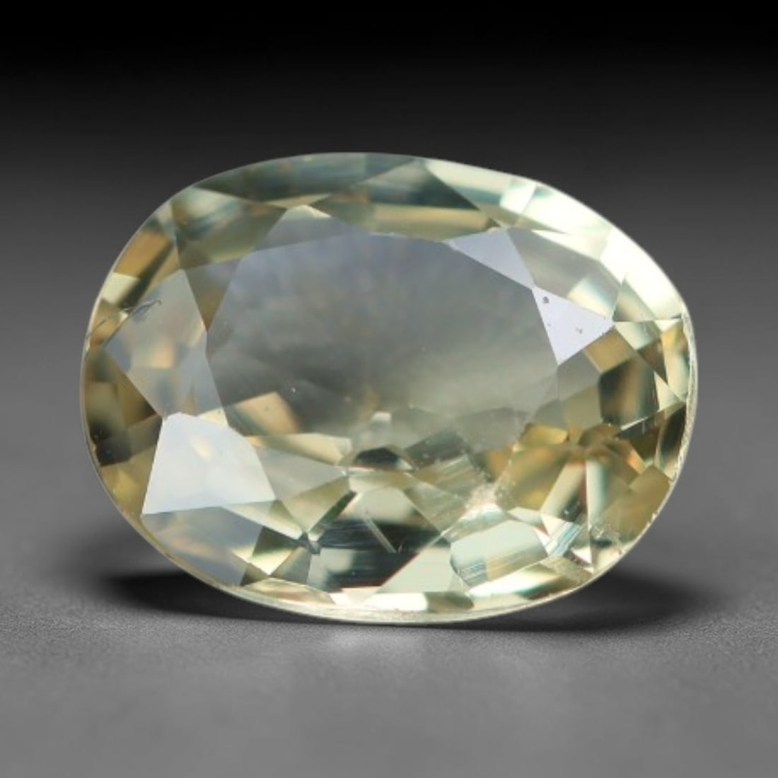 0.57 Carats Natural Pale Yellow Sapphire Oval Faceted Loose Gemstone, 79XV: Natural pale buttery yellow corundum sapphire expertly cut into an oval faceted loose gemstone, detailed with mixed brilliant facets to optimize light return. The crystal features a soft muted pale ye