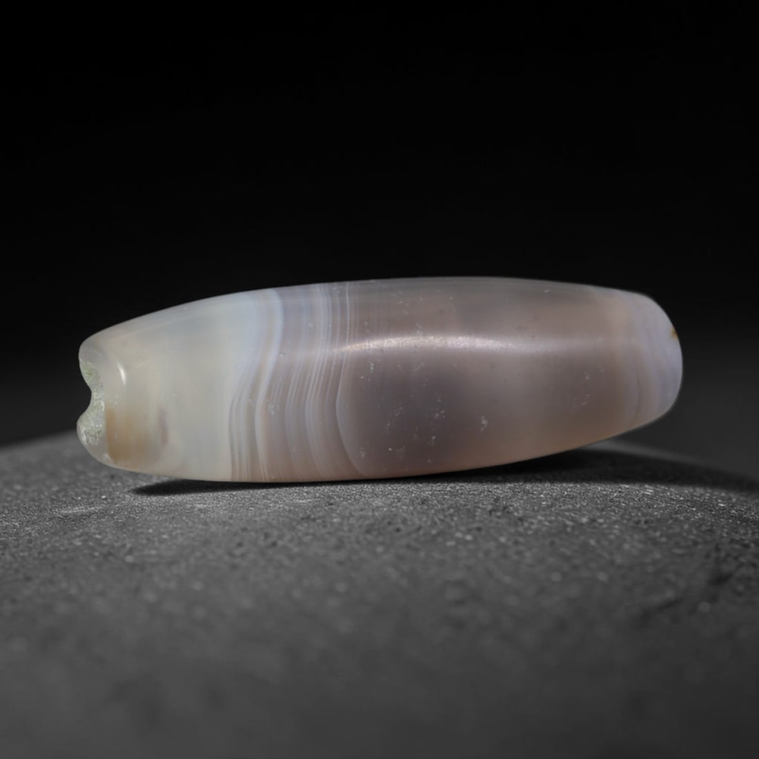 Ancient Medieval Qarakhanid Turkic Culture Banded Agate Cylinder Bead (840-1212 CE), 82XD: This antique slender cylindrical banded agate bead originates from Qarakhanid Turkic Culture, a key medieval Central Asian Silk Road caravan civilization operating bead workshops supplying chalcedony 