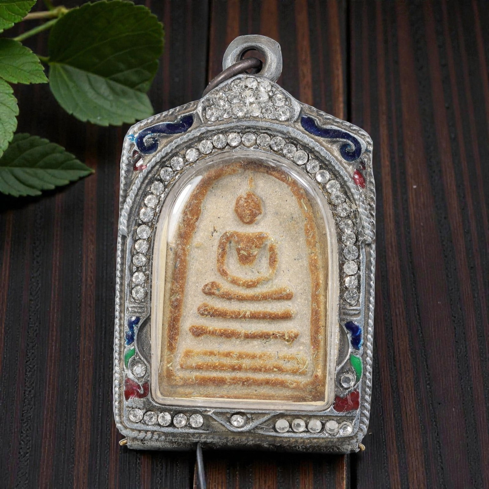 Thai Phra Somdej Amulet - Crystal & Enamel Silver Tone Pendant, 69ZB: A Thai Buddhist Phra Somdej amulet featuring a seated Buddha figure on tiered bases, housed in a silver-tone metal casing with clear crystal and colorful enamel detailing. The glass-fronted enclosure 