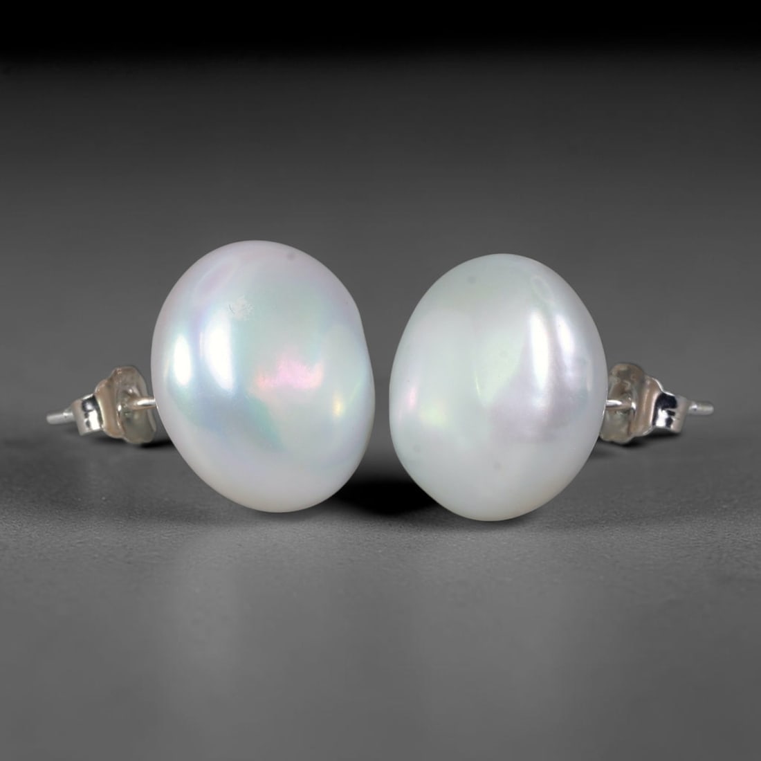 Natural Oval Freshwater Pearl Stud Earrings, 47WE: Classic minimalist stud earrings crafted with matched oval natural freshwater pearls, each measuring 13.6x7.1mm. The pearls feature smooth, thick nacre with soft creamy ivory base tones, accented by d