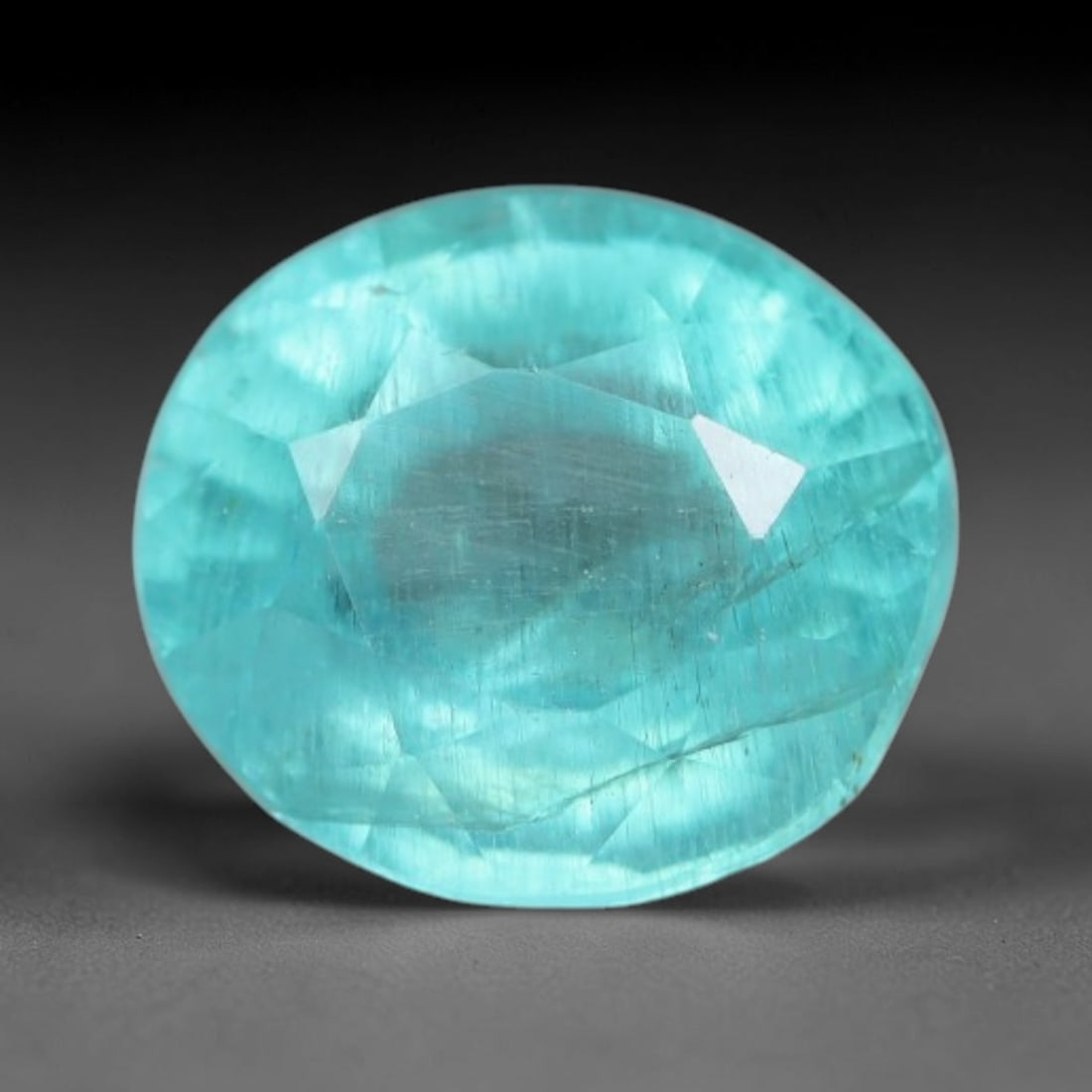 1.29 Carats Natural Bright Cyan Blue Apatite Oval Faceted Loose Gemstone, 11WW: This apatite is sourced from natural mineral deposits and processed with precise faceting and uniform high-gloss polishing by professional lapidary craftsmanship. Natural fibrous textures and tiny sca