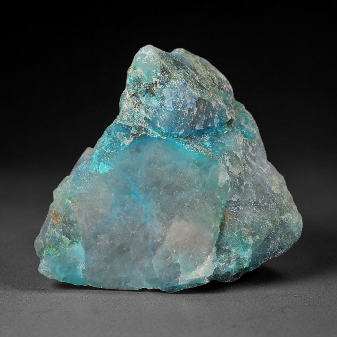 137ct Natural Peruvian Chrysocolla Polished Slab Rough, 54WV: This partial-polished chrysocolla slab features blended mineral matrix with smooth refined face and unaltered natural rugged edge across its 34x29x19mm elongated form, translucent mineral layers hold 